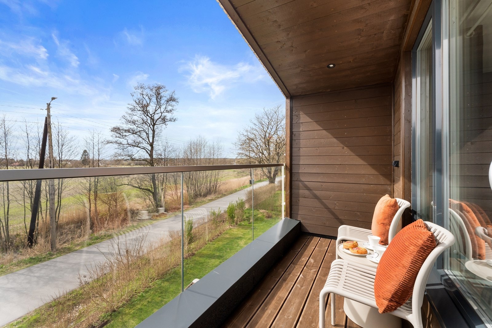 Den sørøstvendte balkongen på ca. 4 m² er en privat uteplass med glassrekkverk og utsikt. Galleribilde