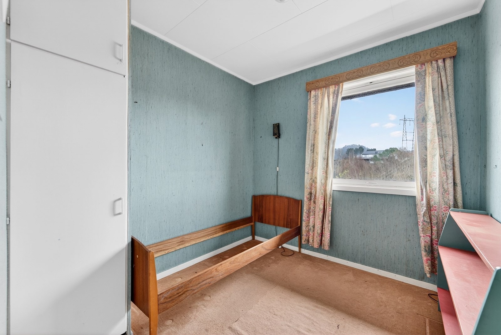 Soverom 3 av 3. Rommet har tapetserte slette vegger, tepper på gulv og et innebygget skap. Galleribilde