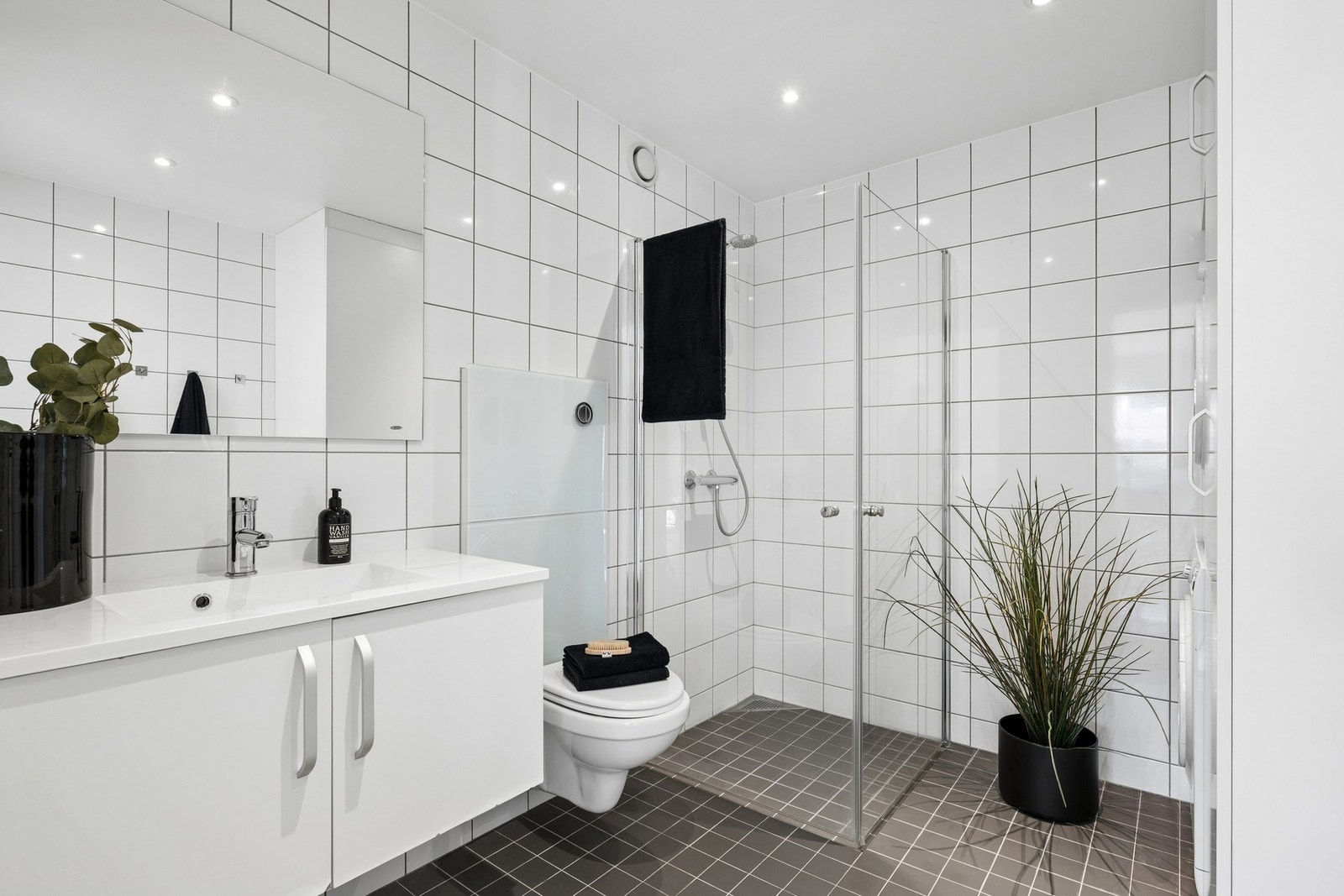 Baderommet er lyst og tidløst med downlights, varmekabler og opplegg for vaskemaskin. Galleribilde