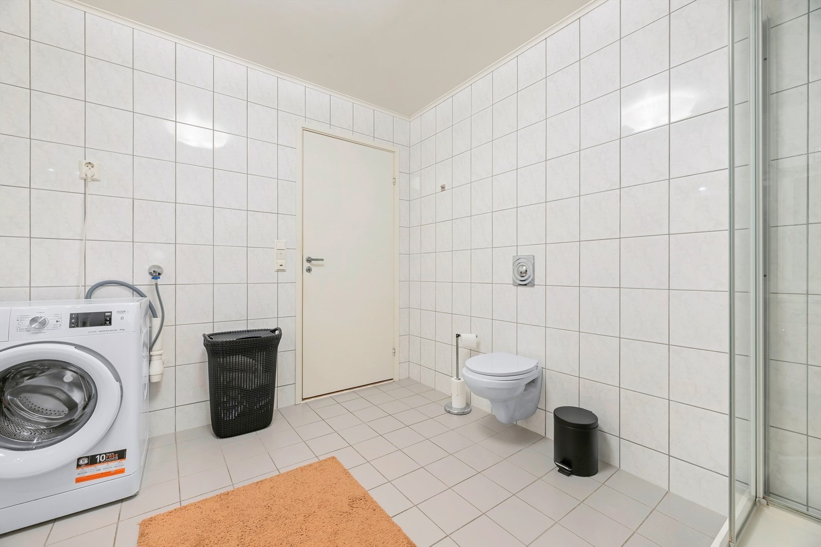 Badet er utstyrt med veggmontert toalett, opplegg for vaskemaskin. Galleribilde