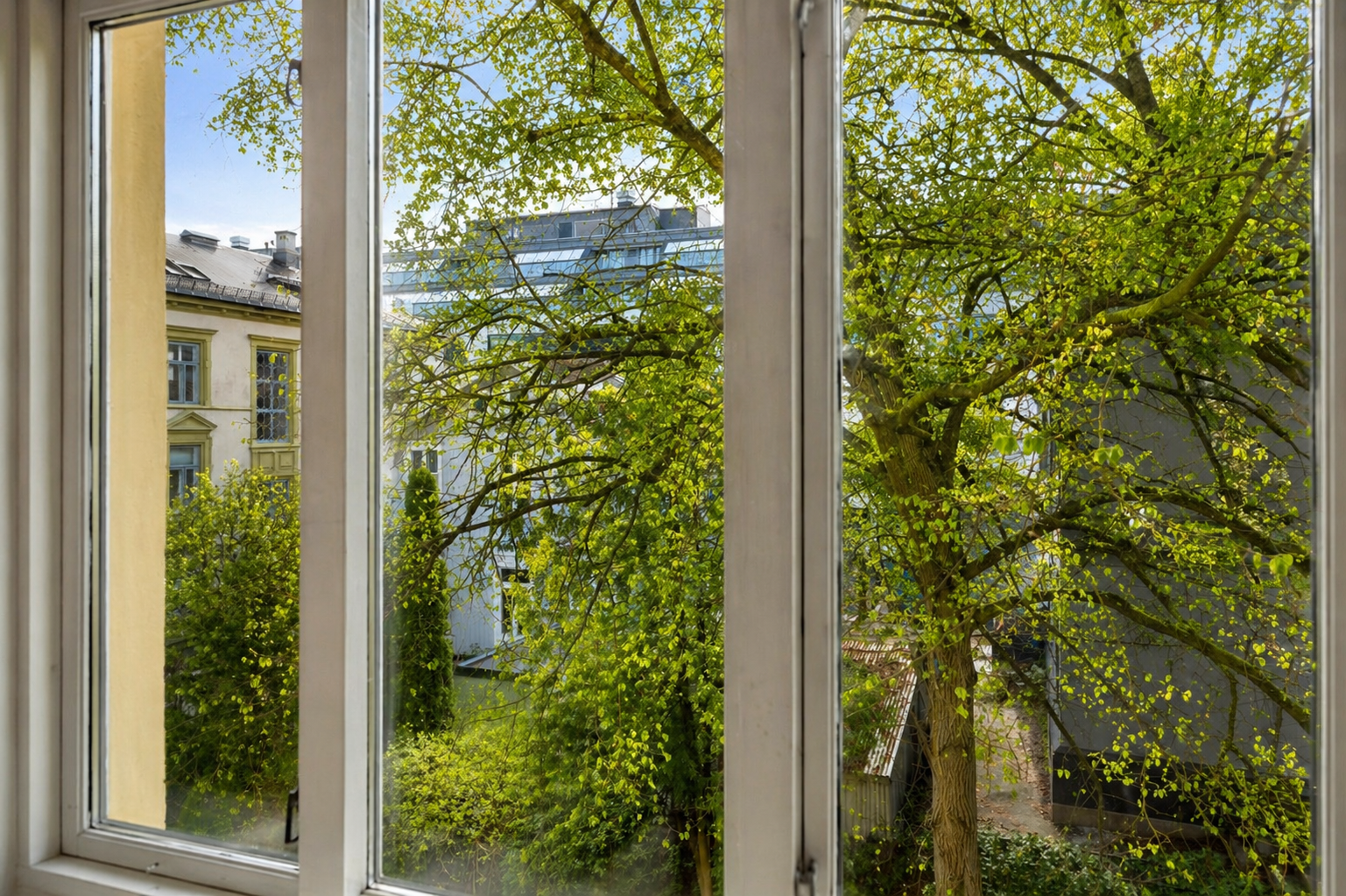 Leiligheten ligger skjermet til med et frodig utsyn mot bakgård. (AI-redigert). Galleribilde