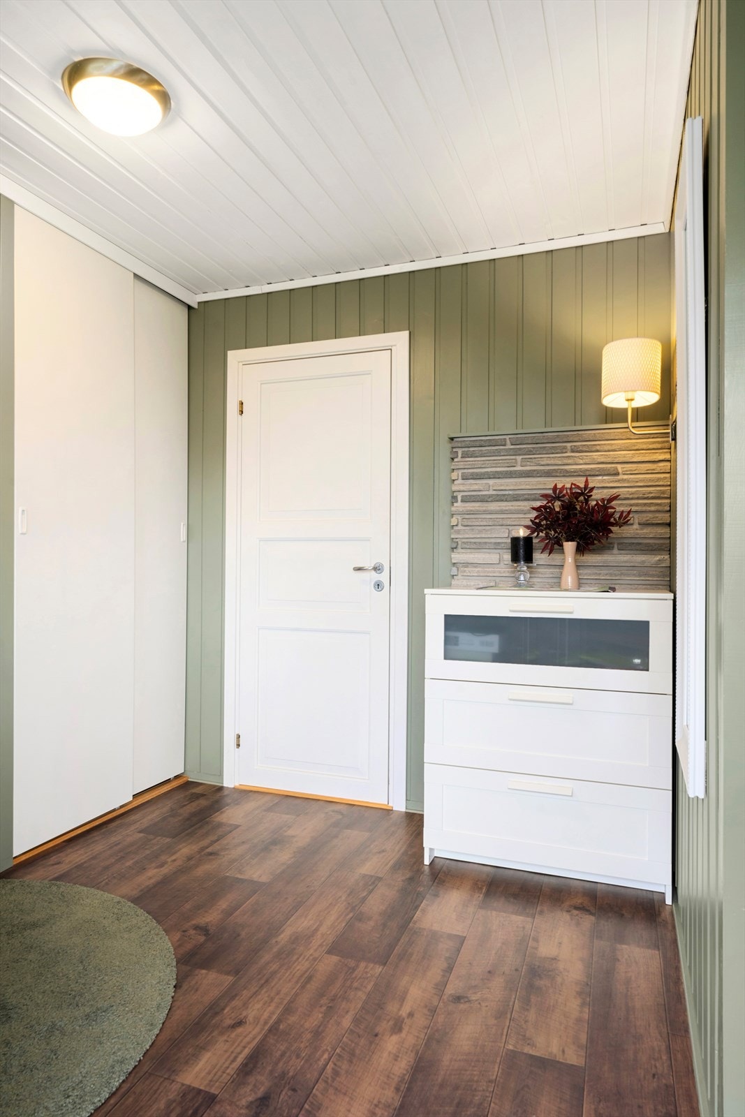 Entréen har gulvbelegg og panel på veggene, med praktisk oppbevaring i garderobeskap. Galleribilde