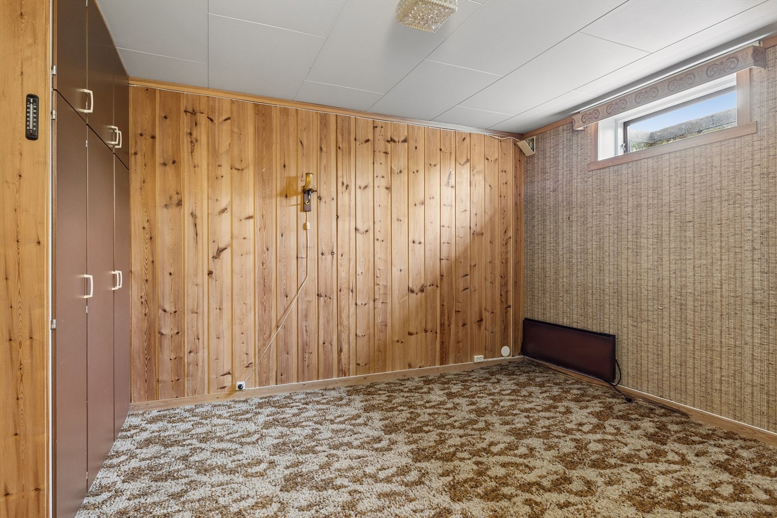 Enda et innredet rom i kjelleren, med teppe på gulvet og garderobeskap. Galleribilde