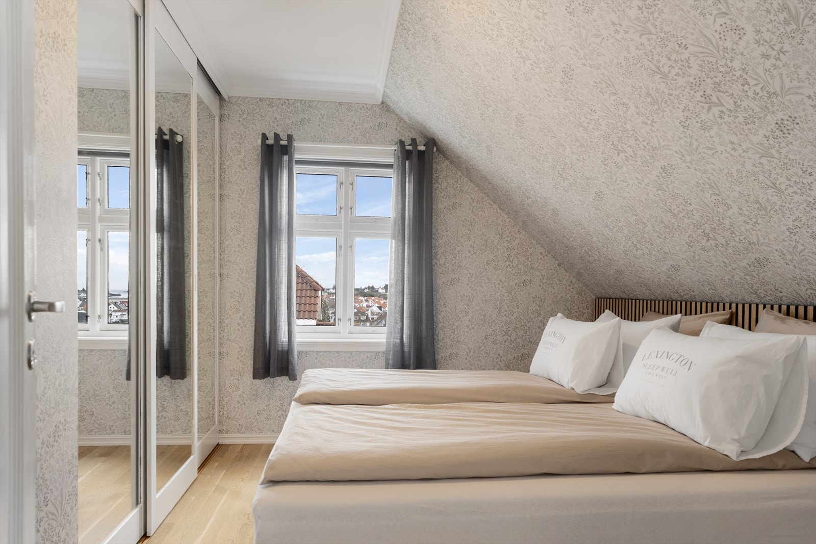 Stort og innbydende hovedsoverom med romslig skyvedørsgarderobe - i ca. 2023 ble soverommet tapetsert og det ble montert dekorativ spilevegg bak sengen Galleribilde
