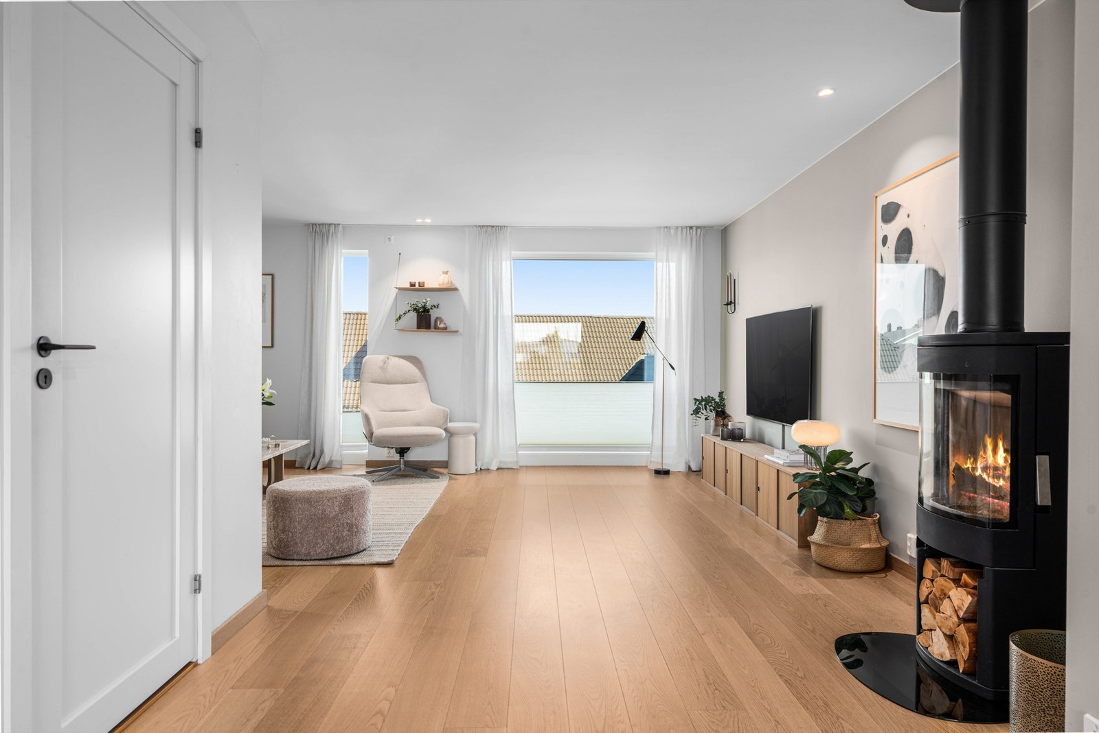 Ildstedet fra byggeåret er plassert sentralt i etasjen og gir både varme og hygge. Galleribilde