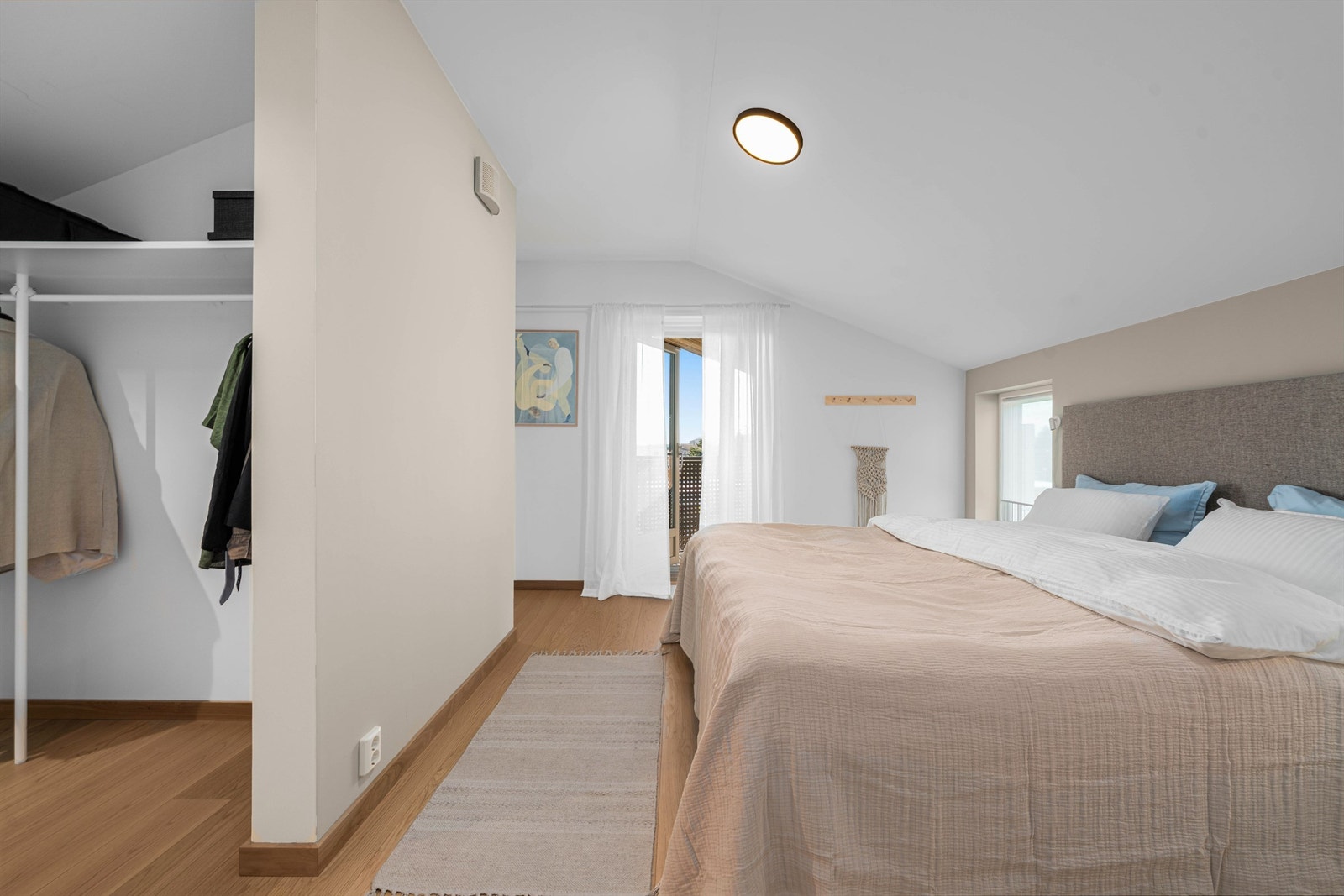 En smart løsning med en halvvegg skiller sovesonen fra en romslig walk-in-garderobe. Galleribilde