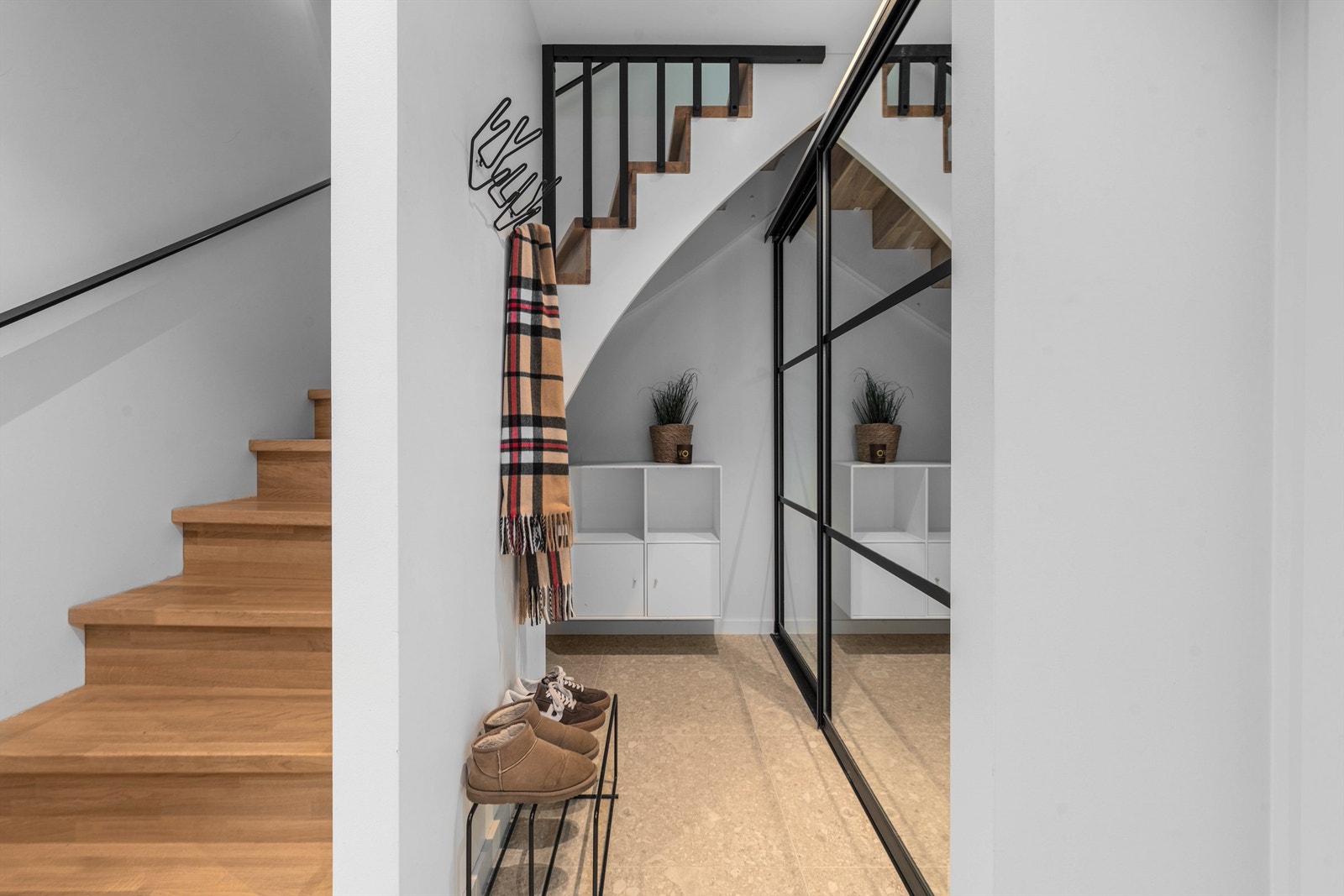 Under trappen er det plassbygget en romslig skyvedørsgarderobe som gir gode oppbevaringsmuligheter. Galleribilde