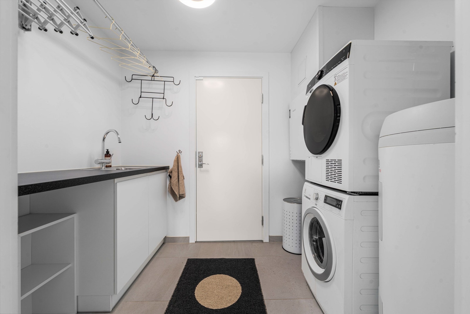 Vaskerommet er utstyrt med gulvvarme, utslagsvask og opplegg for vaskemaskin og tørketrommel. Her er også boligens tekniske anlegg som sentralstøvsuger og balansert ventilasjon plassert. Galleribilde