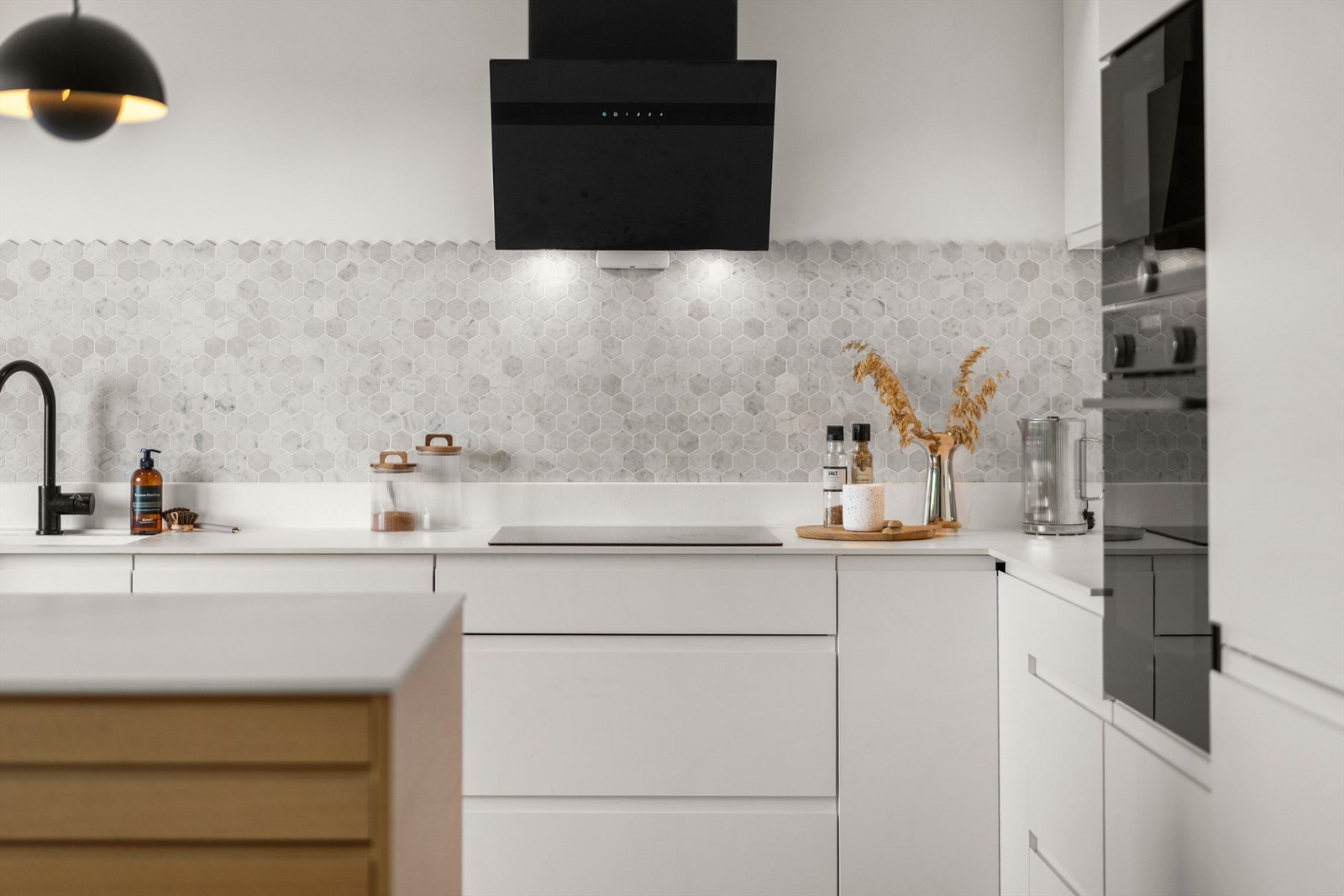 Benkeplaten er i slitesterk kompaktlaminat, og over induksjonstoppen er det montert en moderne ventilator. Galleribilde