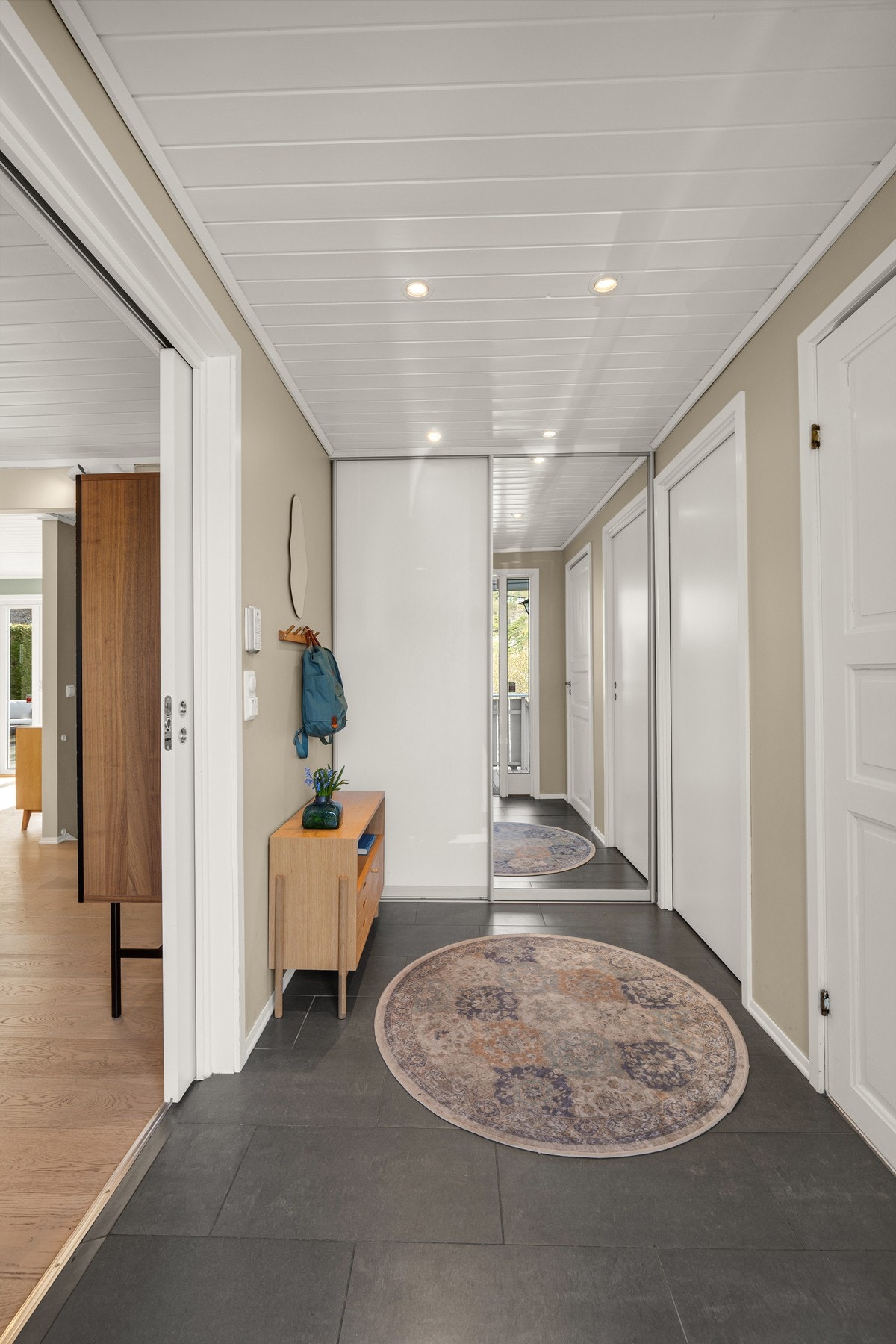 Entréen har flislagt gulv med gulvvarme, downlights belysning og skyvedørsgarderobe Galleribilde