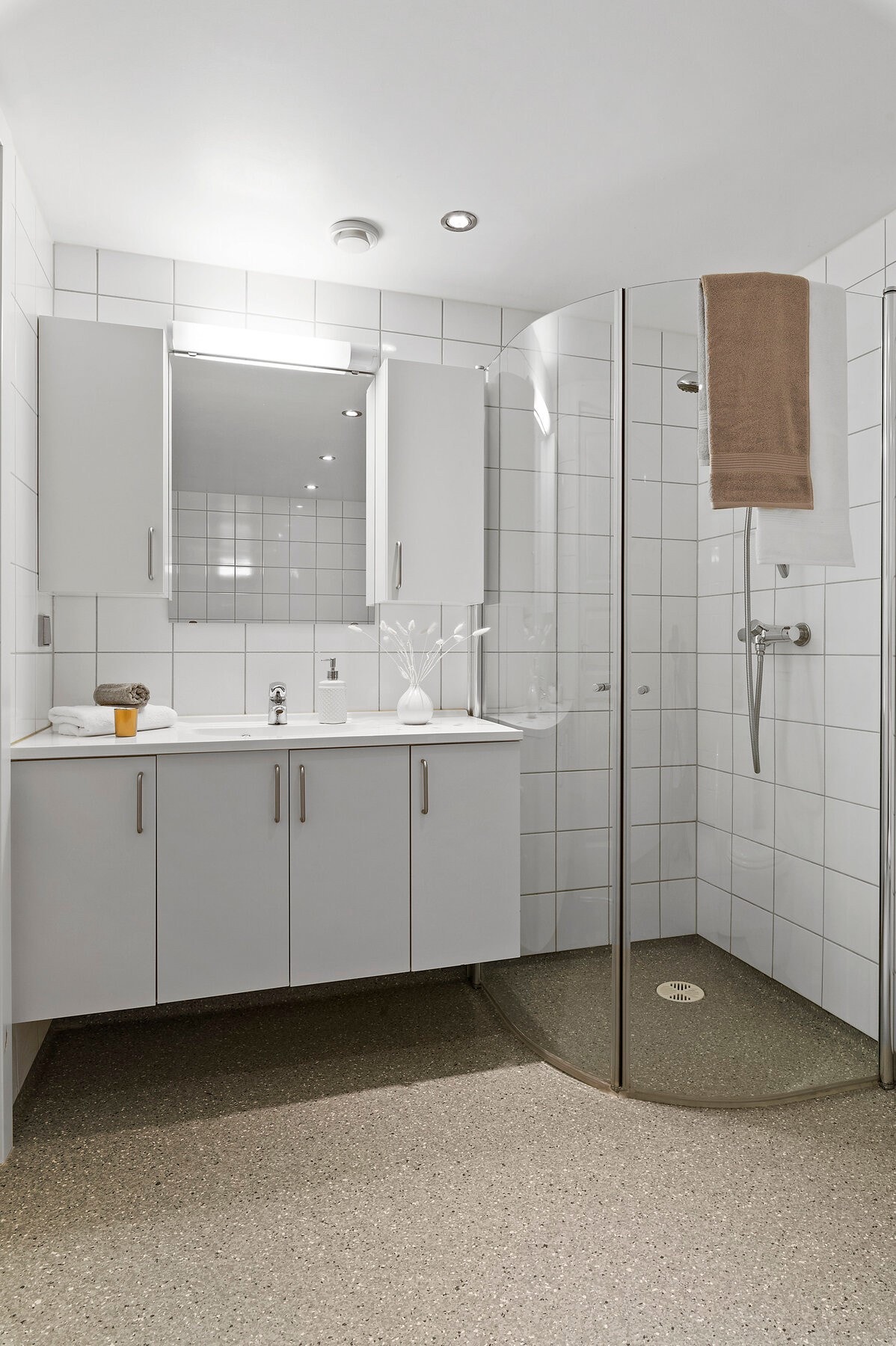 Bad med dusjhjørne, vegghengt toalett og romslig servant med oppbevaringsmuligheter. Samt opplegg for vaskemaskin. Galleribilde