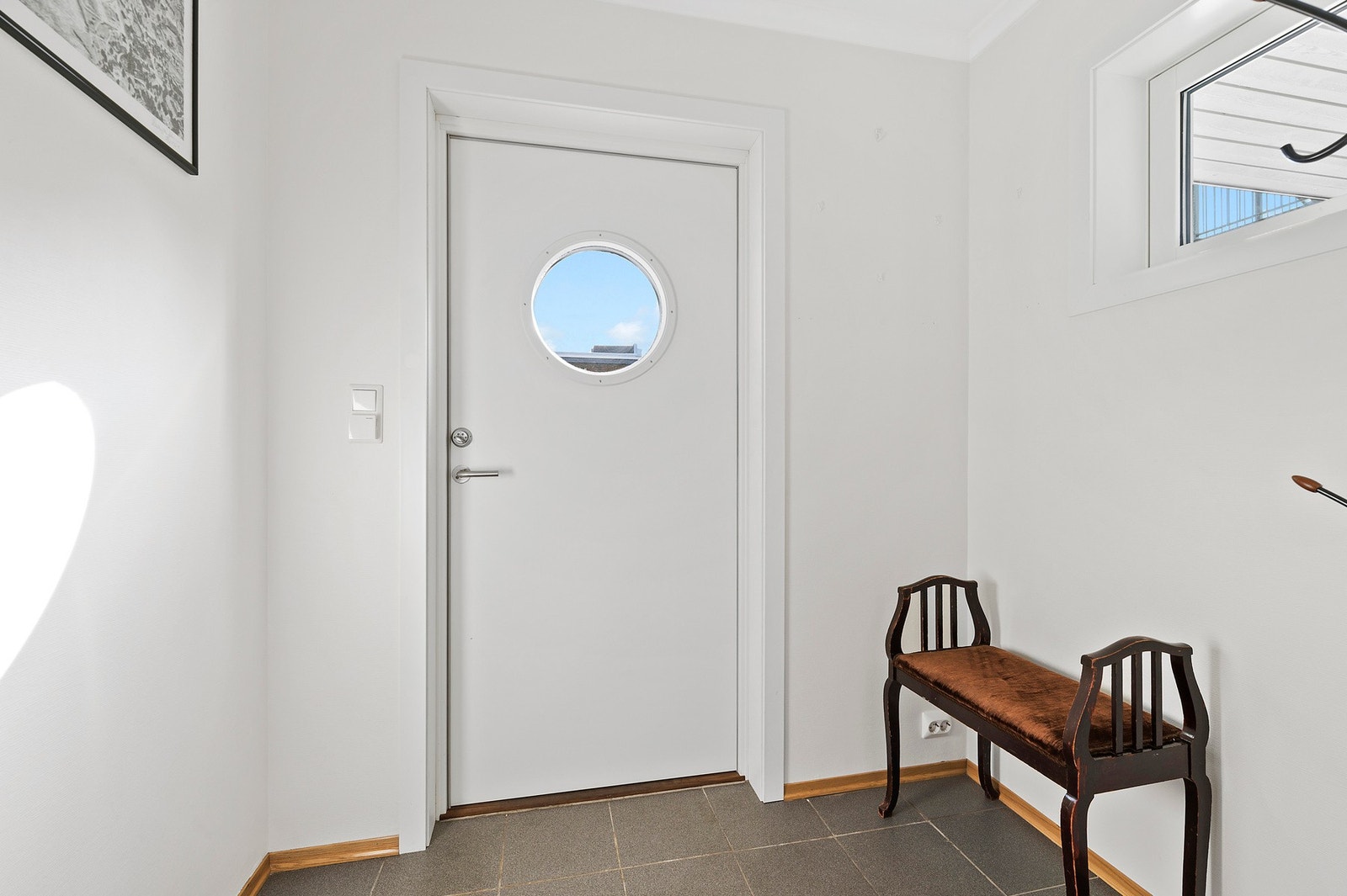 Entré med flislagt gulv og plass til oppbevaring. Galleribilde