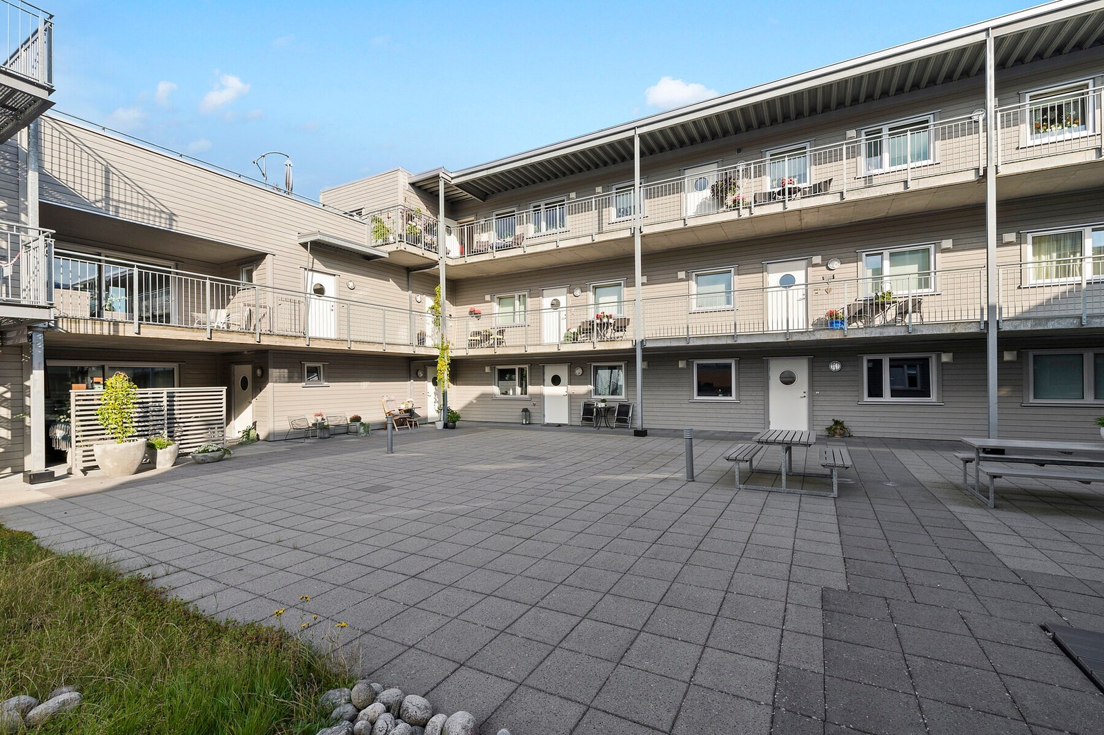 Leiligheten vender mot felles atrium med sittegrupper Galleribilde