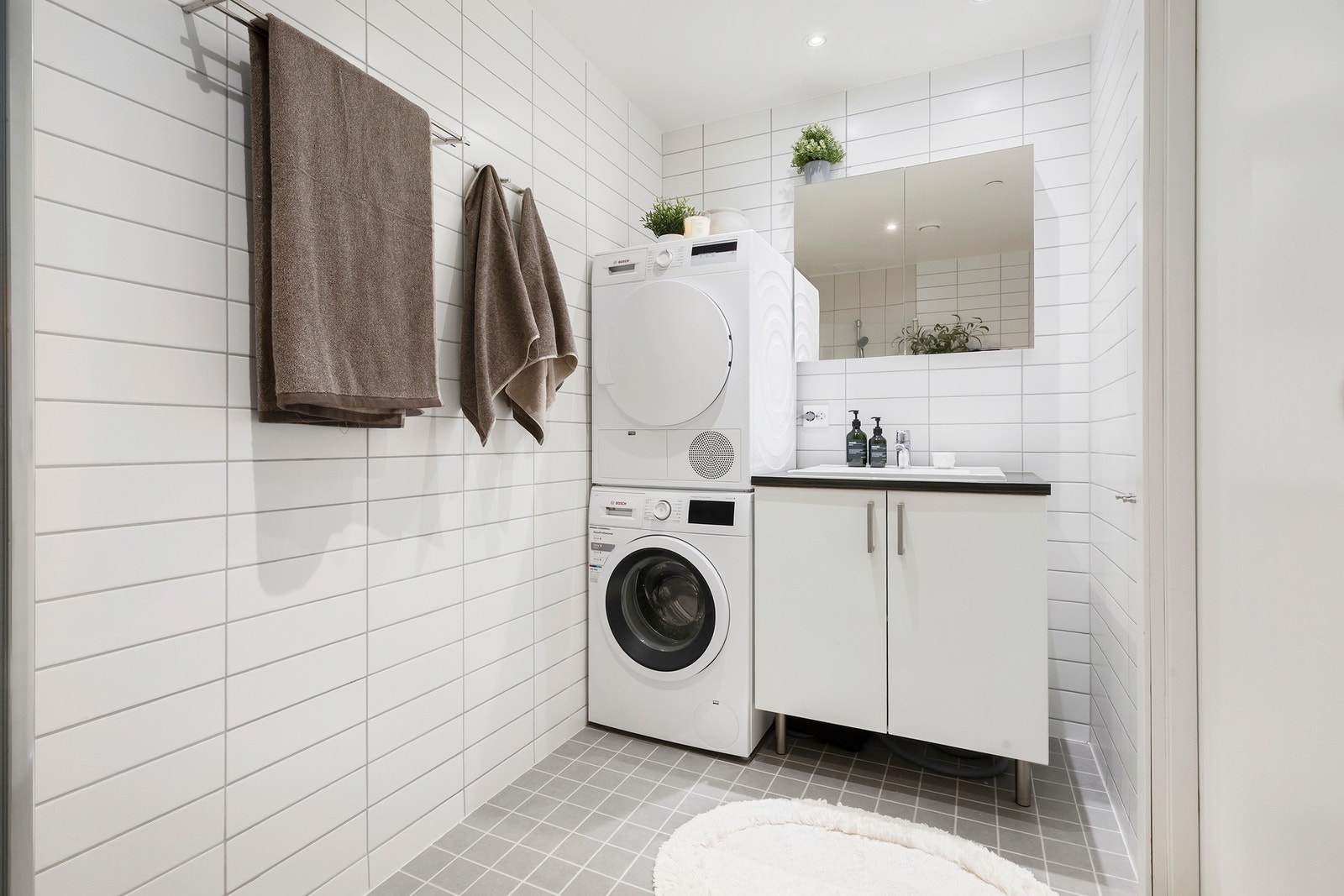 Badet har oppbevaringsmuligheter og opplegg for vaskemaskin og tørketrommel Galleribilde