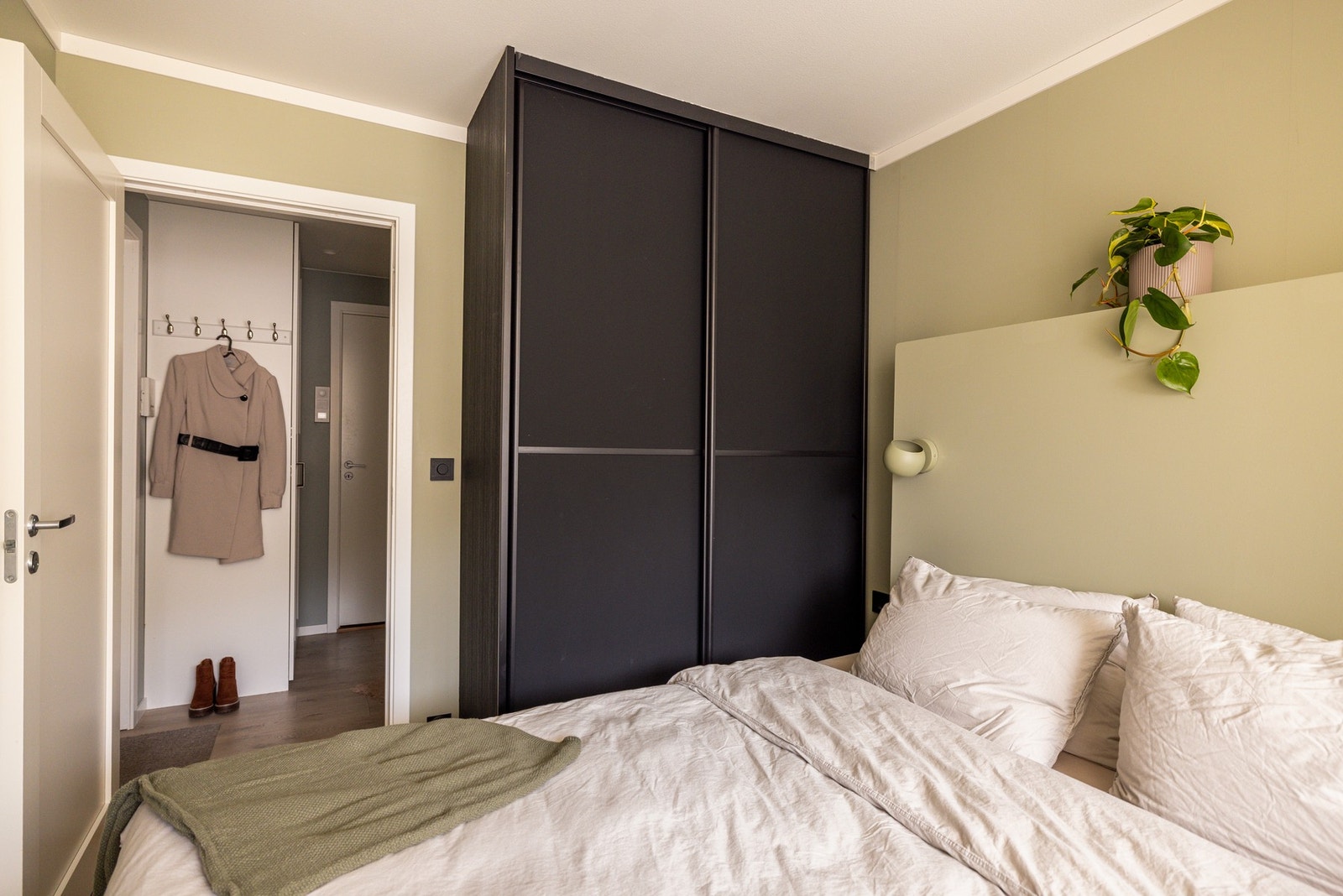 Det er god oppbevaringsplass i plassbygget sort skyvedørsgarderobe. Galleribilde