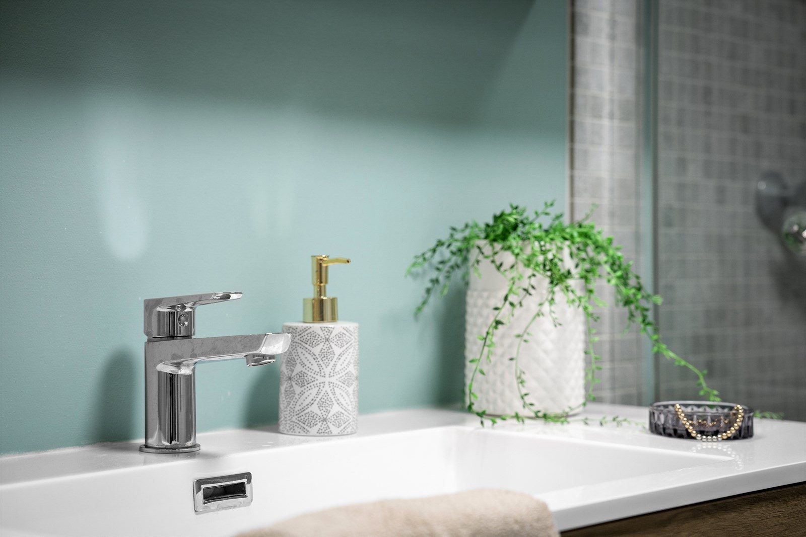 Badet er lekkert med grå fliser, vegghengt toalett, regndusj og dusjvegg i klart glass. Nytt i 2025. Pen innredning med speilskap. Galleribilde