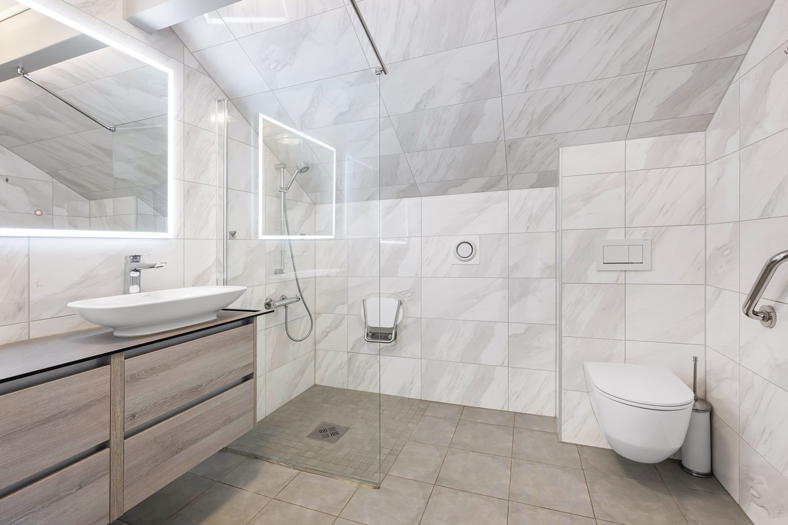 Badet er et av leilighetens høydepunkter, oppgradert for få år siden med fliser, varmekabler i gulvet og moderne innredning. Galleribilde
