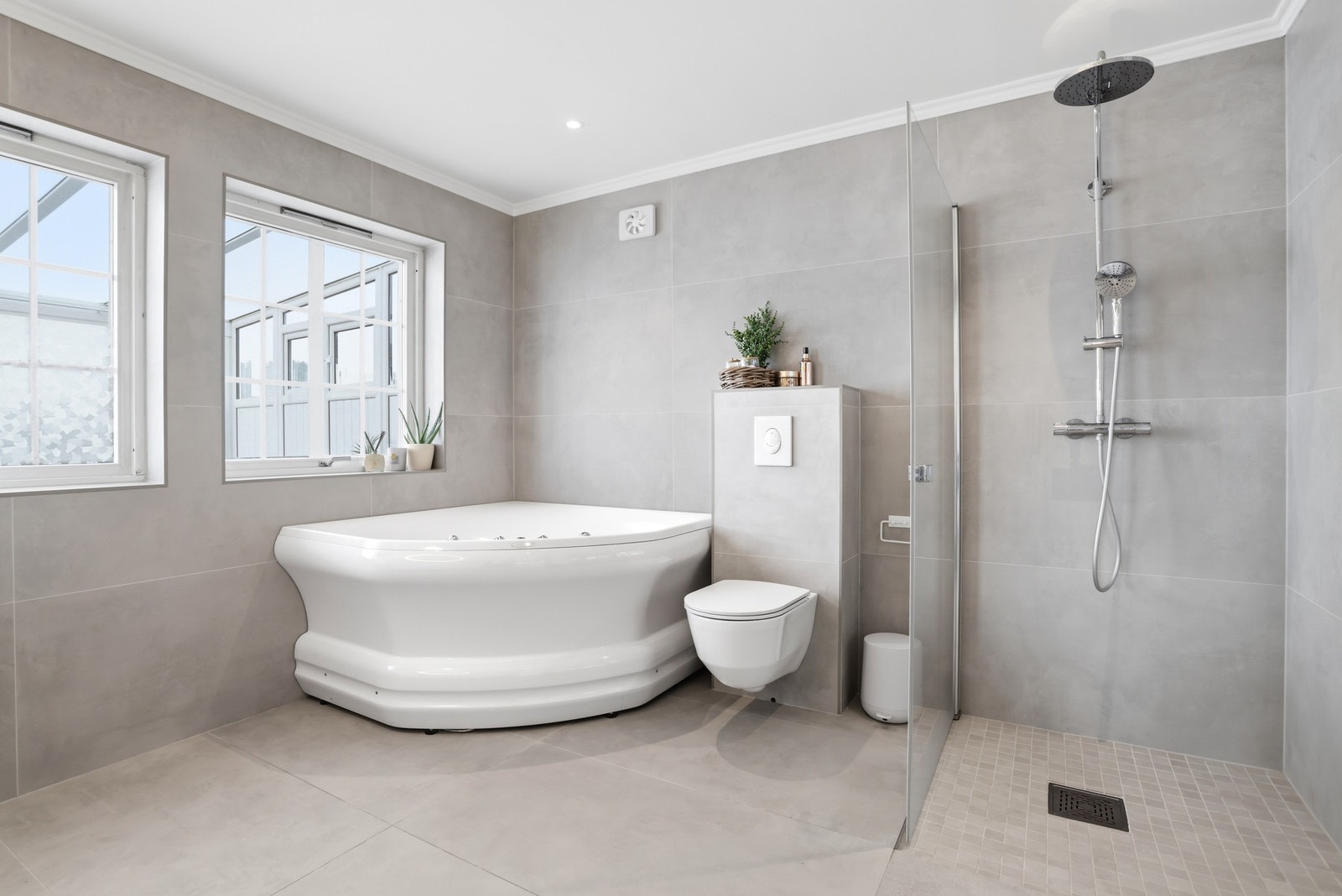 Baderom med badekar og dusjsone, samt veggehengt toalett. Badet er pusset opp i 2025 Galleribilde