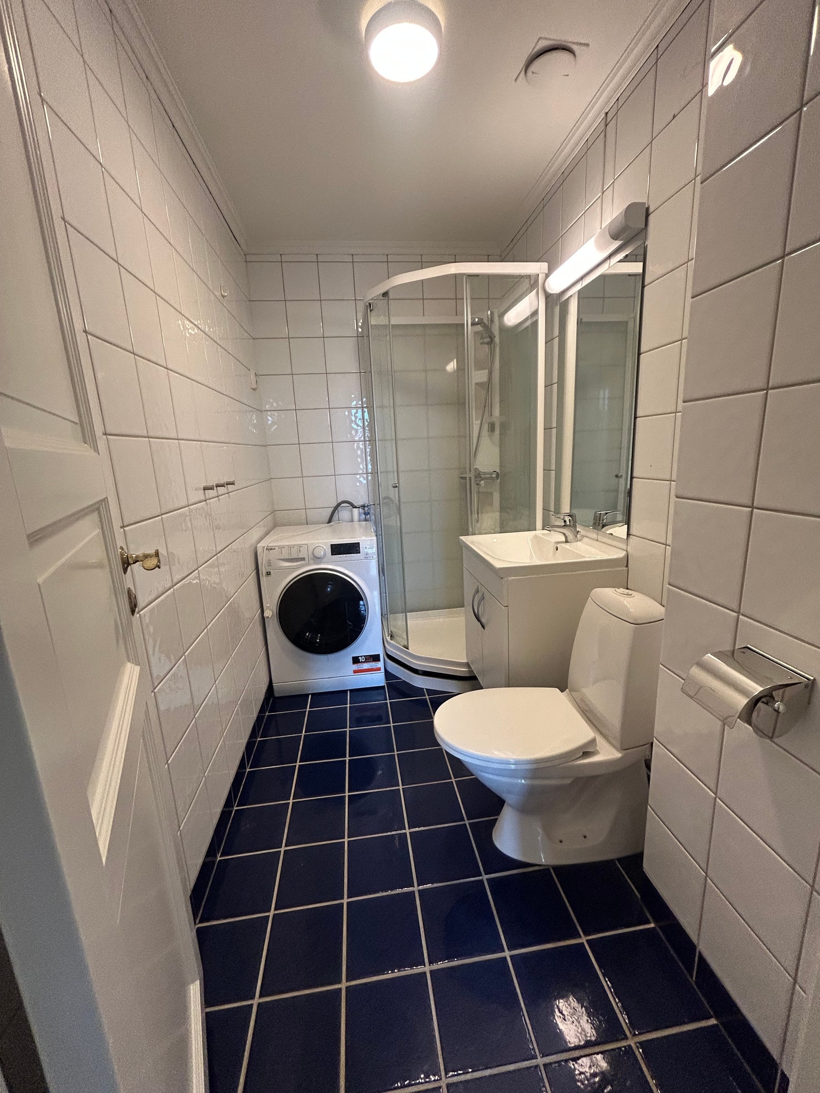 Flislagt bad med vaskemaskin installert. Galleribilde