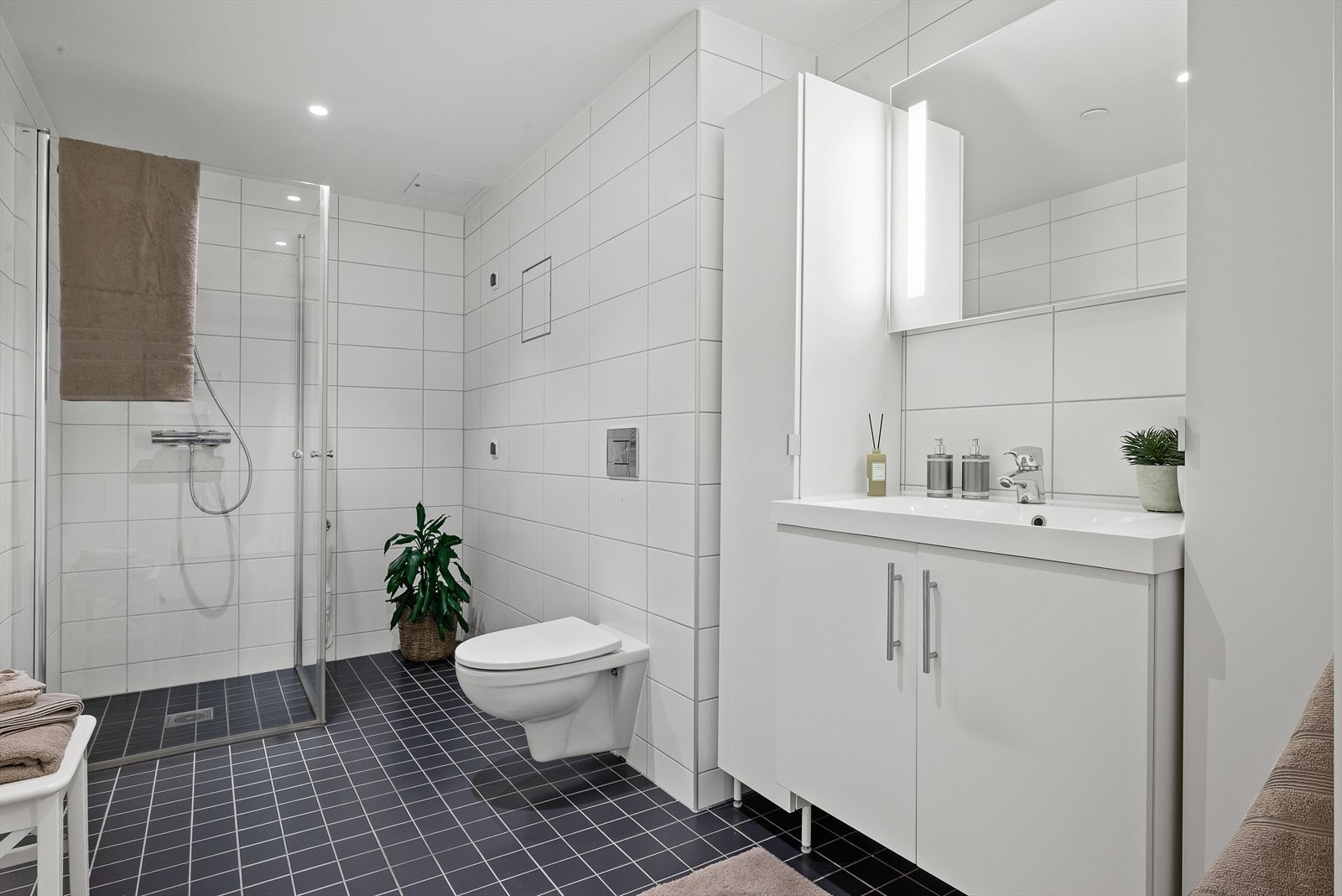Badet er på 6,5 kvm og har en praktisk innredning med mye skapplass, fliser på veggene og flislagt gulv med lun gulvvarme. Galleribilde
