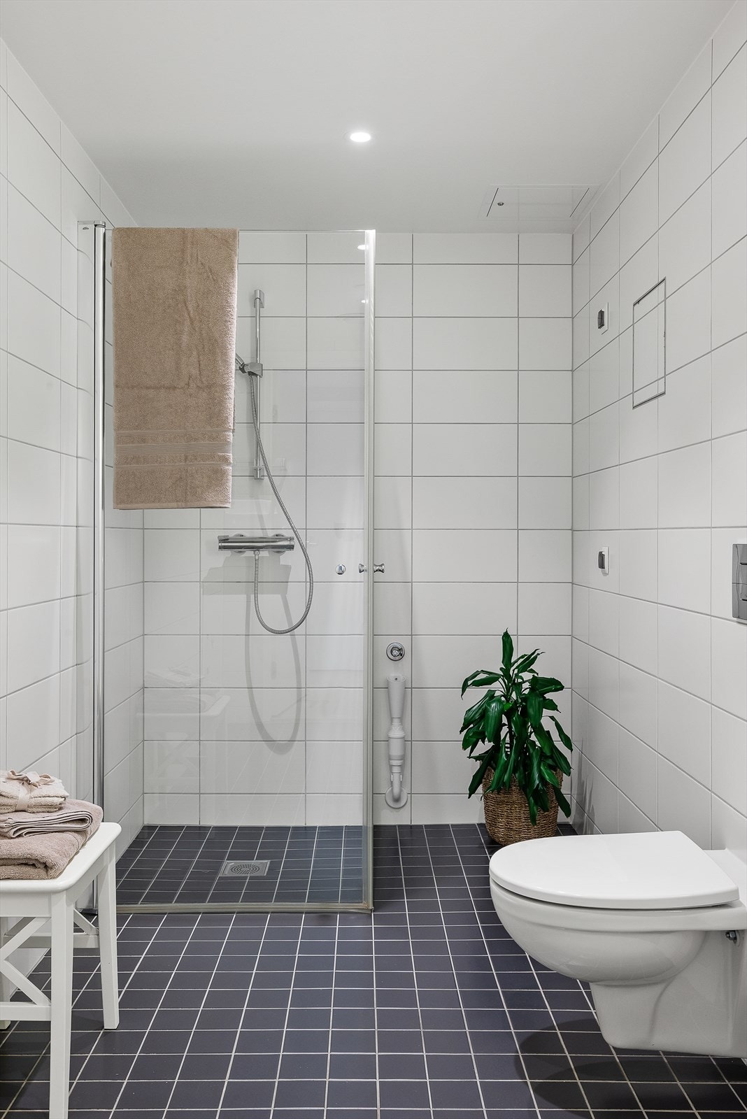 Videre finner du et lekkert dusjhjørne med sammenslåbare dusjvegger og vegghengt wc. Det er opplegg for vaskemaskin og tørketrommel i hjørnet ved dusjen. Galleribilde