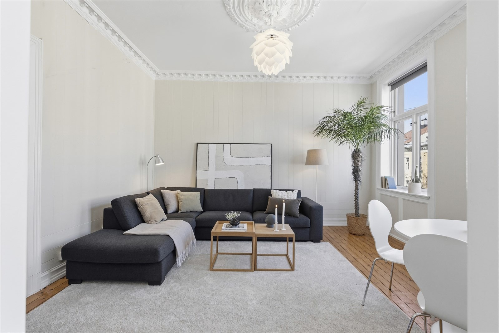 Nymalt stue med god takhøyde, klassisk stukatur, rosett og rikelig plass til sofagruppe. Galleribilde
