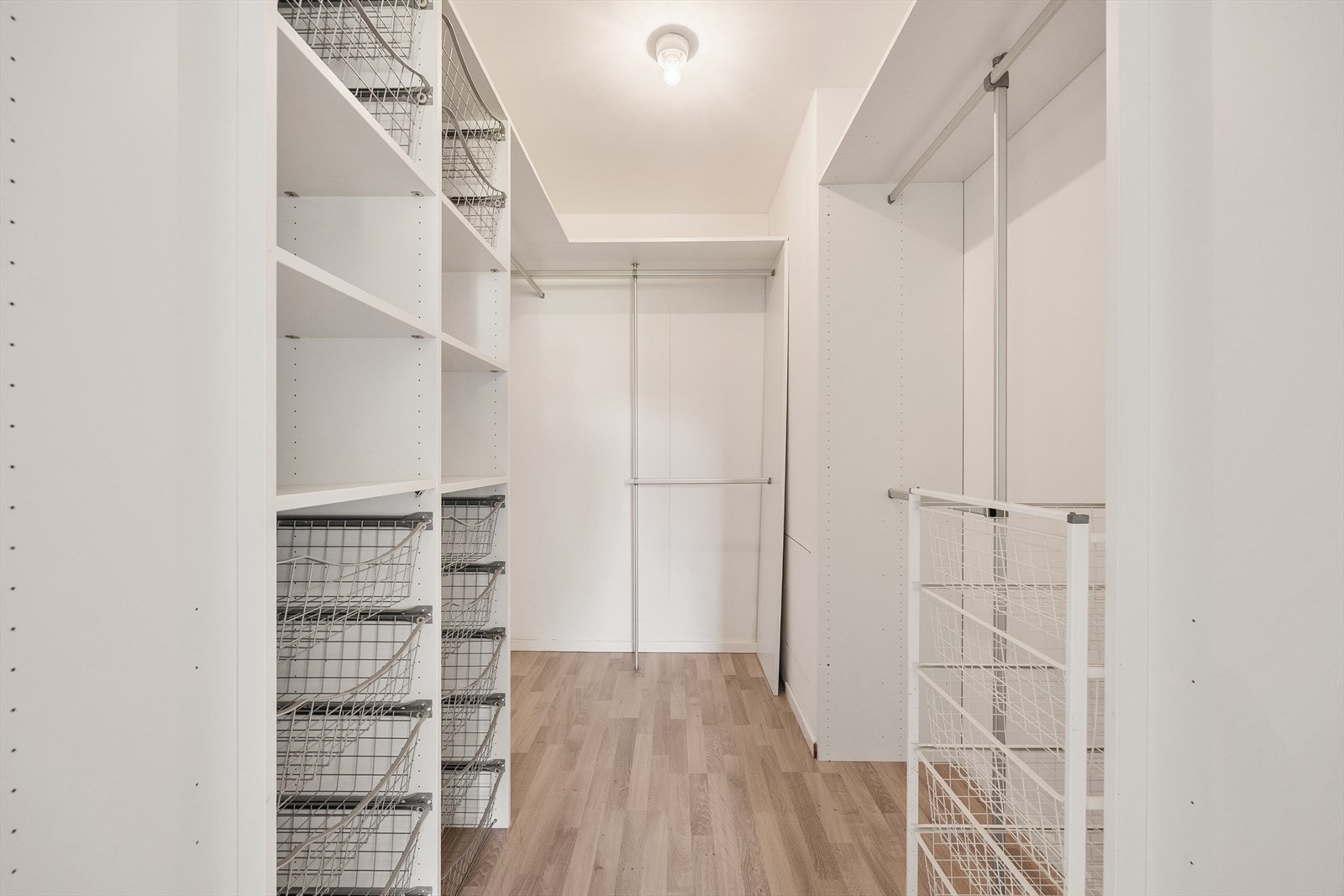 Den praktiske walk-in-garderoben er innredet med et fleksibelt hyllesystem som gir rikelig med oppbevaringsplass. Galleribilde