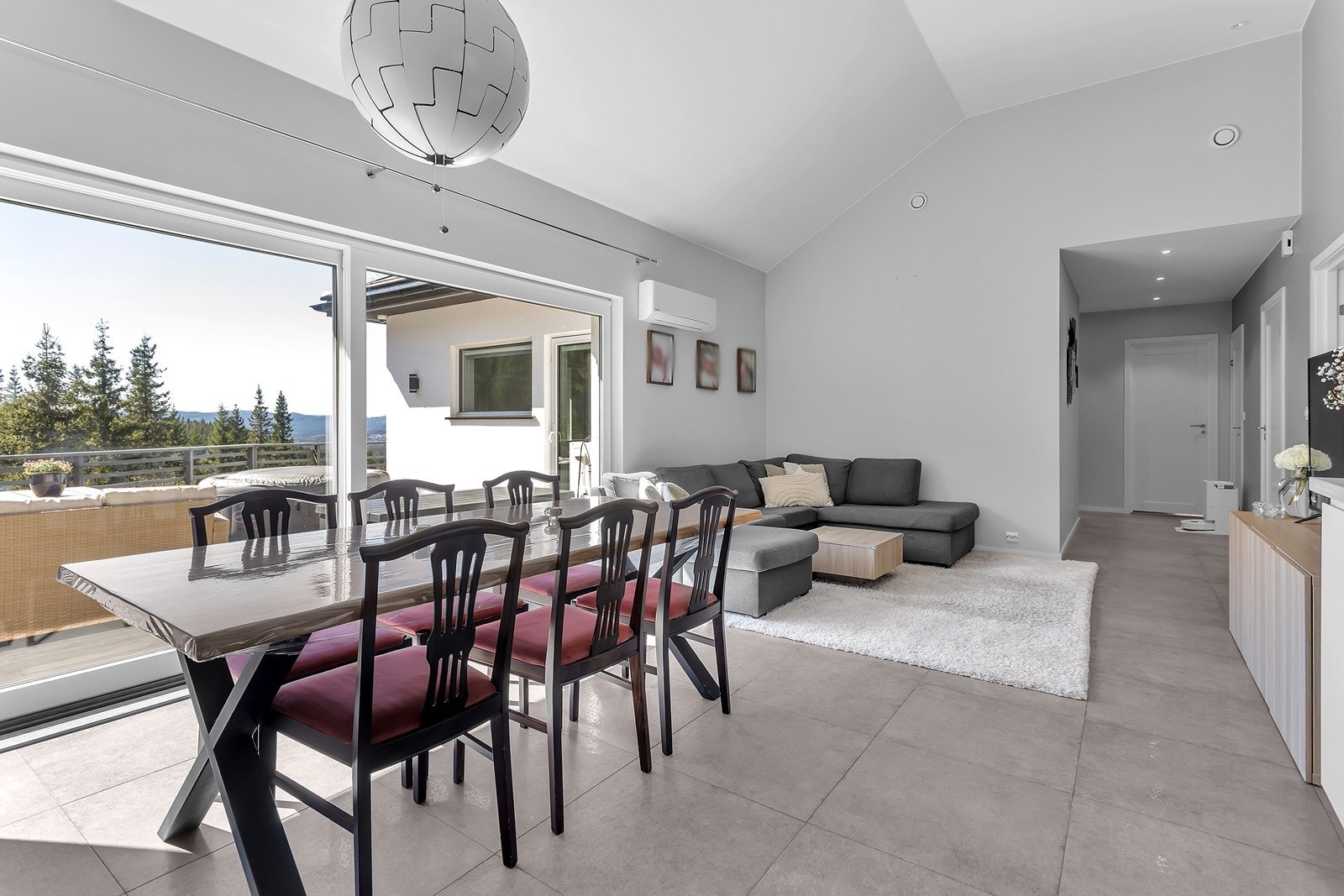 Fra stua er det utgang til solrik veranda som går på tre sider av huset Galleribilde