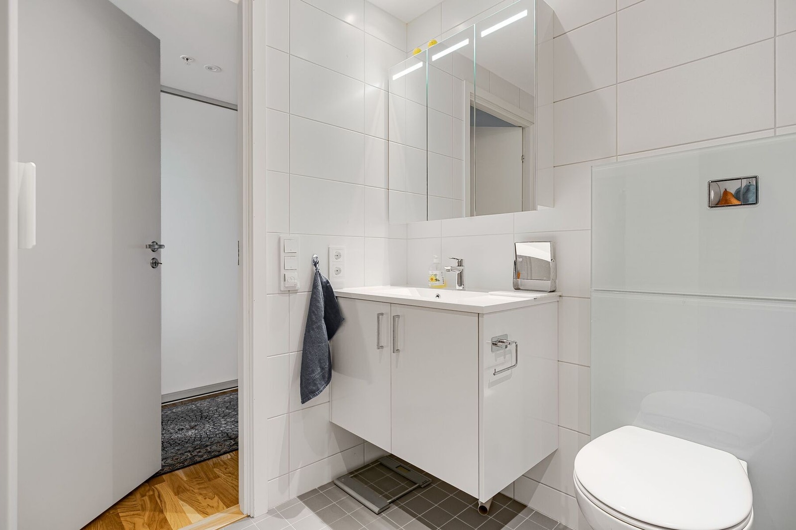 Badet er utstyrt med servant i innredning, dusjplass, toalett og opplegg for vaskemaskin Galleribilde