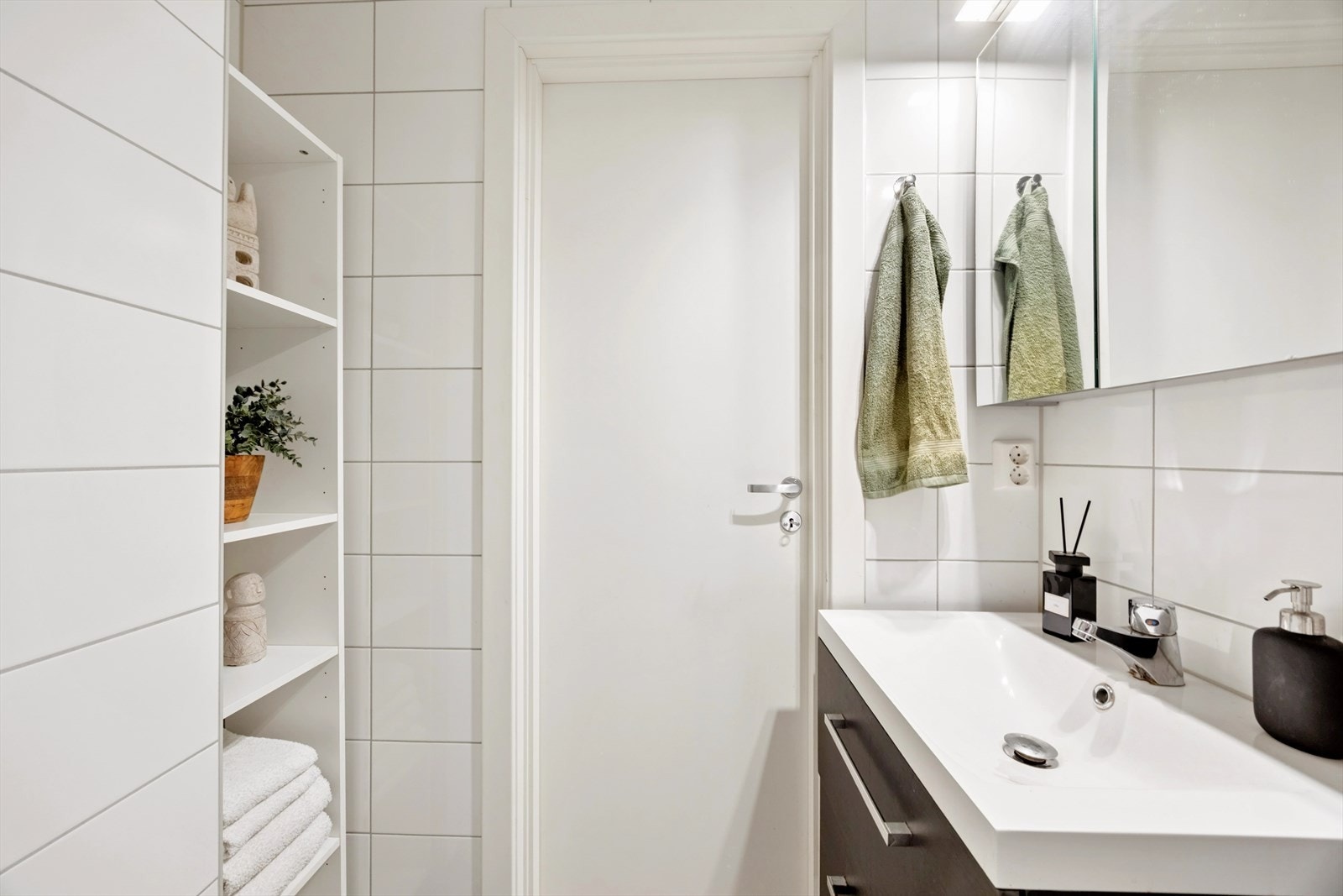 Baderommet har moderne innredning, høyskap, dusjhjørne med svingdører for optimal plassutnyttelse og veggmontert toalett. Galleribilde