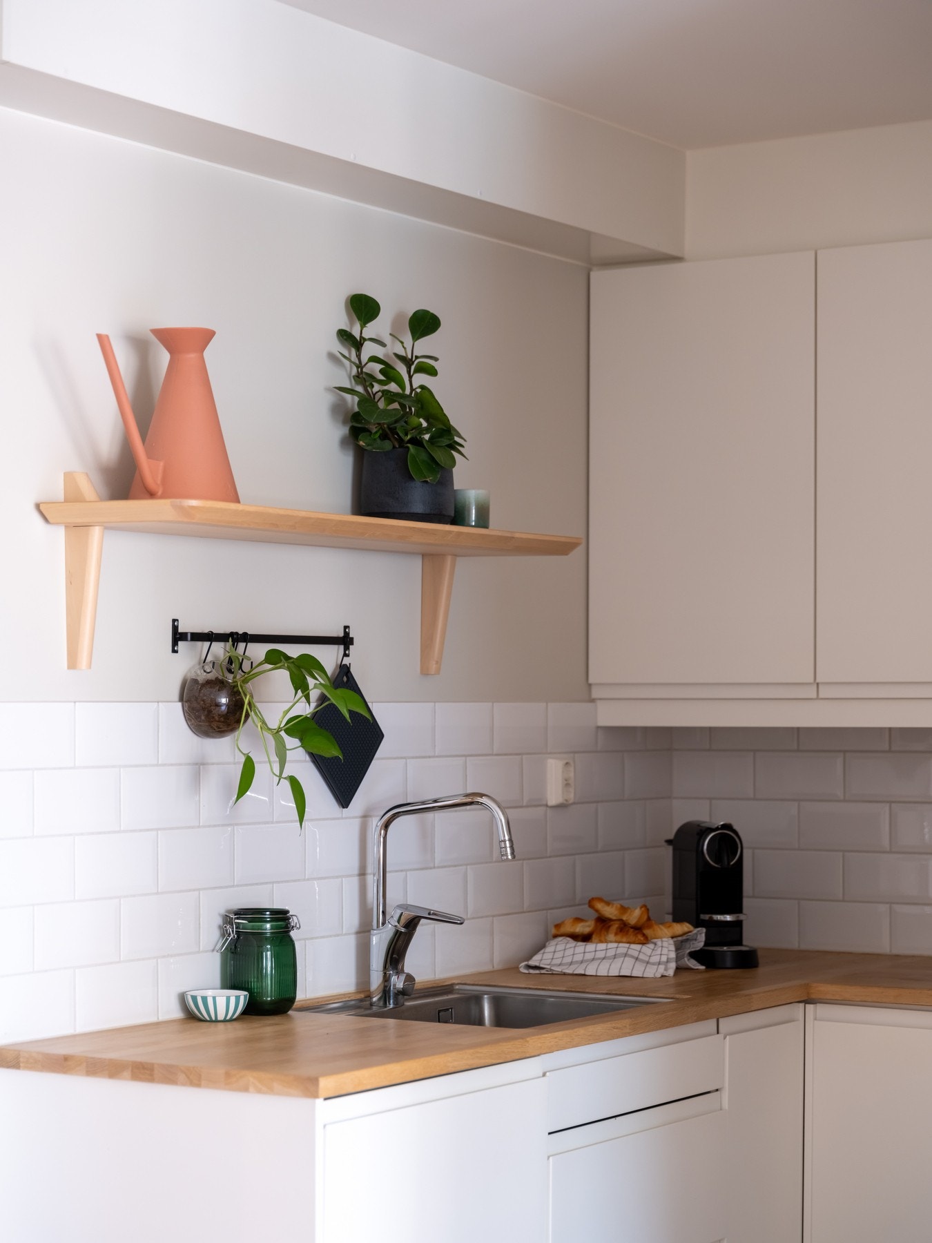 Lys, slett innredning med benkeplate av heltre og oppvaskkum av stål. Galleribilde