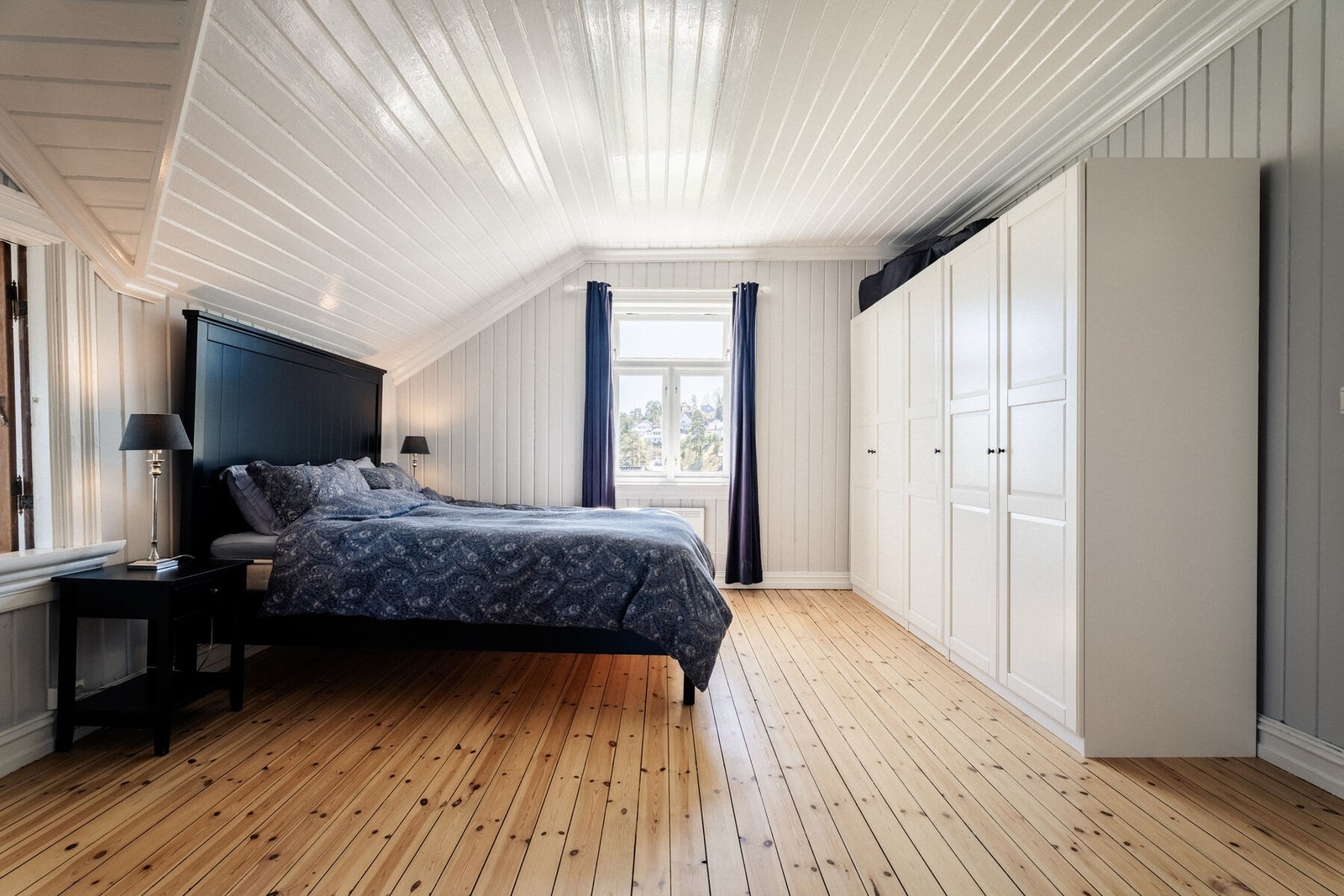 Hovedsoverommet er romslig med originale furuplanker i gulvet, hvitmalt panel i tak og vegger. Galleribilde