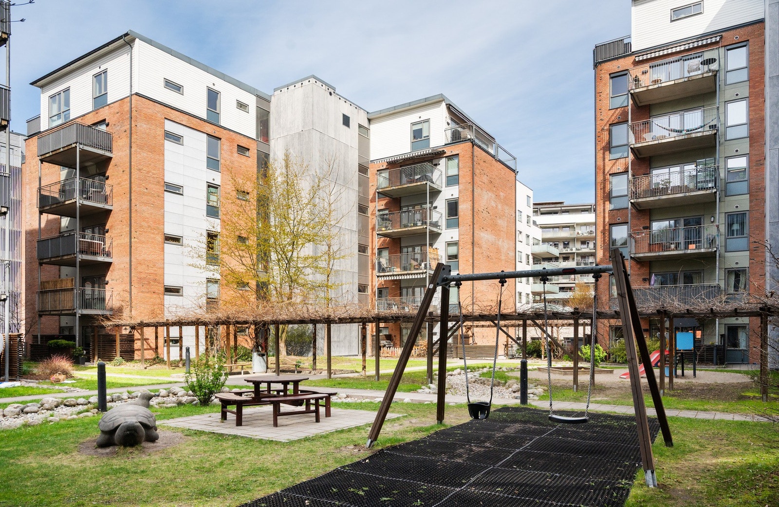 Hyggelig og barnevennlig bakgård med lekeplass og grønne omgivelser Galleribilde