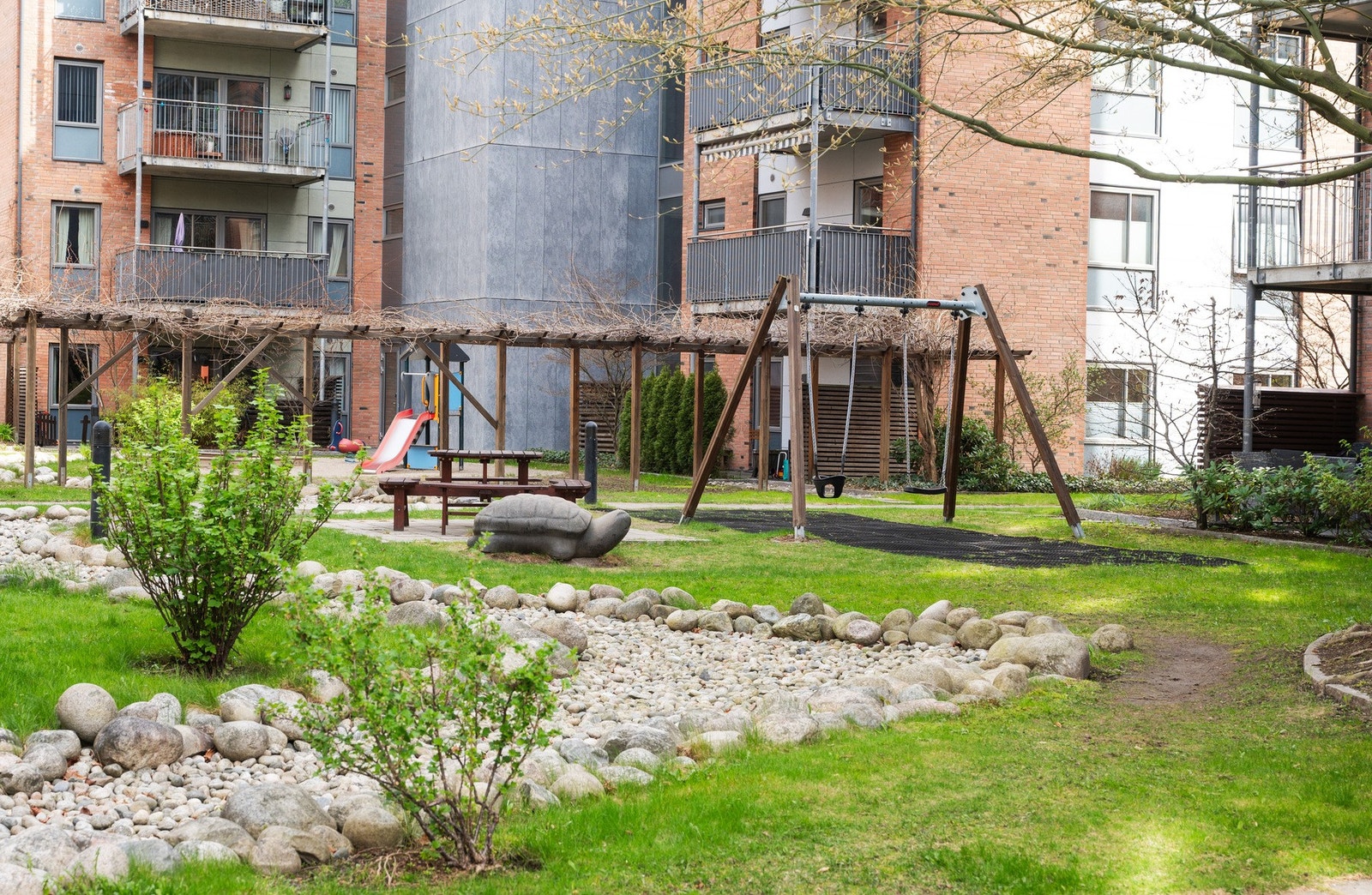 Hyggelig og barnevennlig bakgård med lekeplass og utemøbler Galleribilde