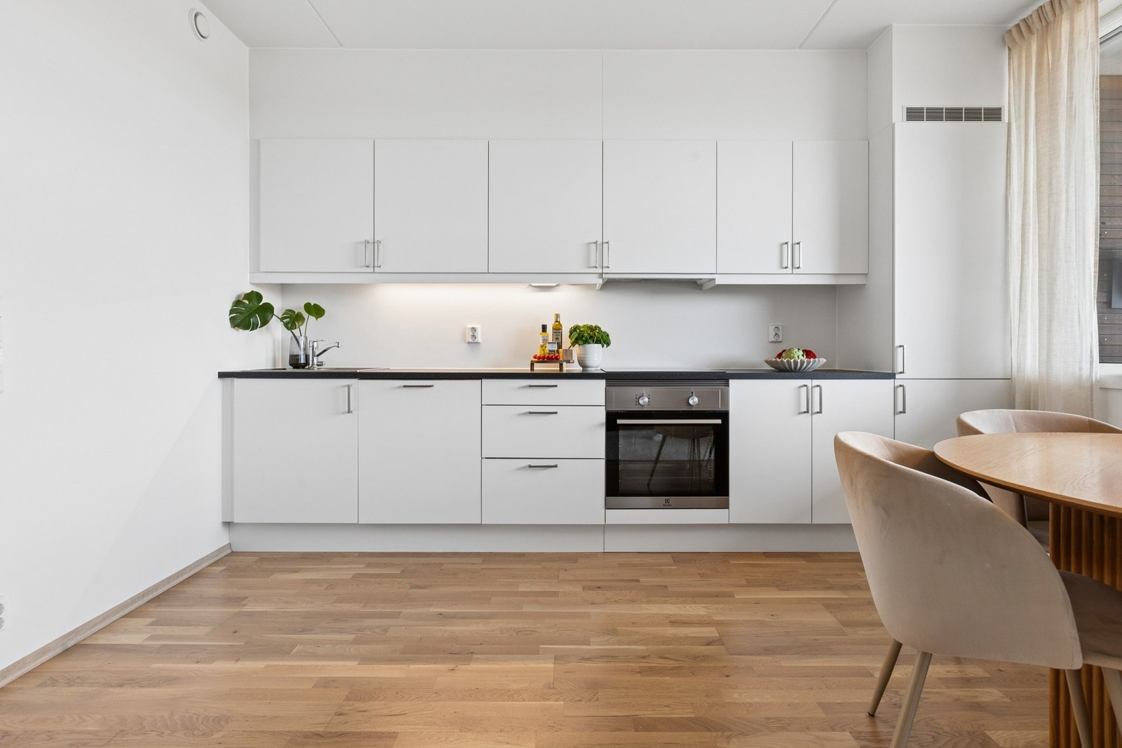 Kjøkkenet ligger i åpen løsning mot stuen og fremstår moderne, funksjonelt og arealeffektivt. Galleribilde
