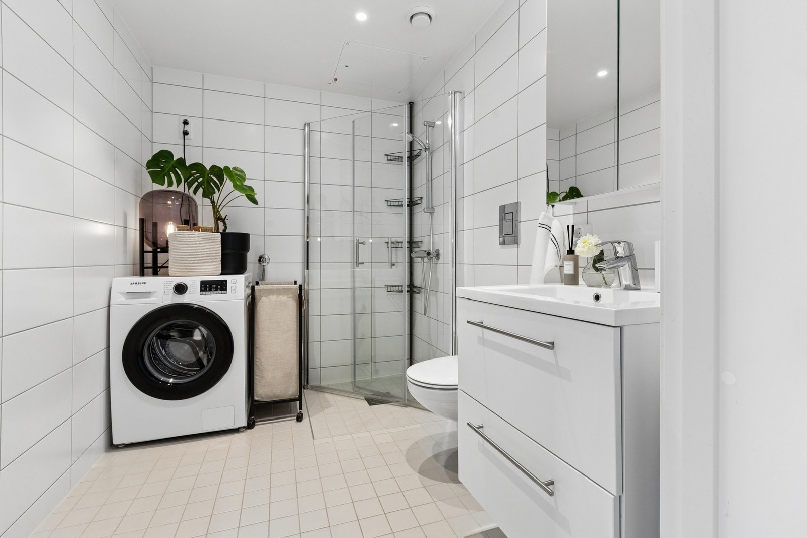 Badet fremstår moderne og delikat med flislagte overflater Galleribilde
