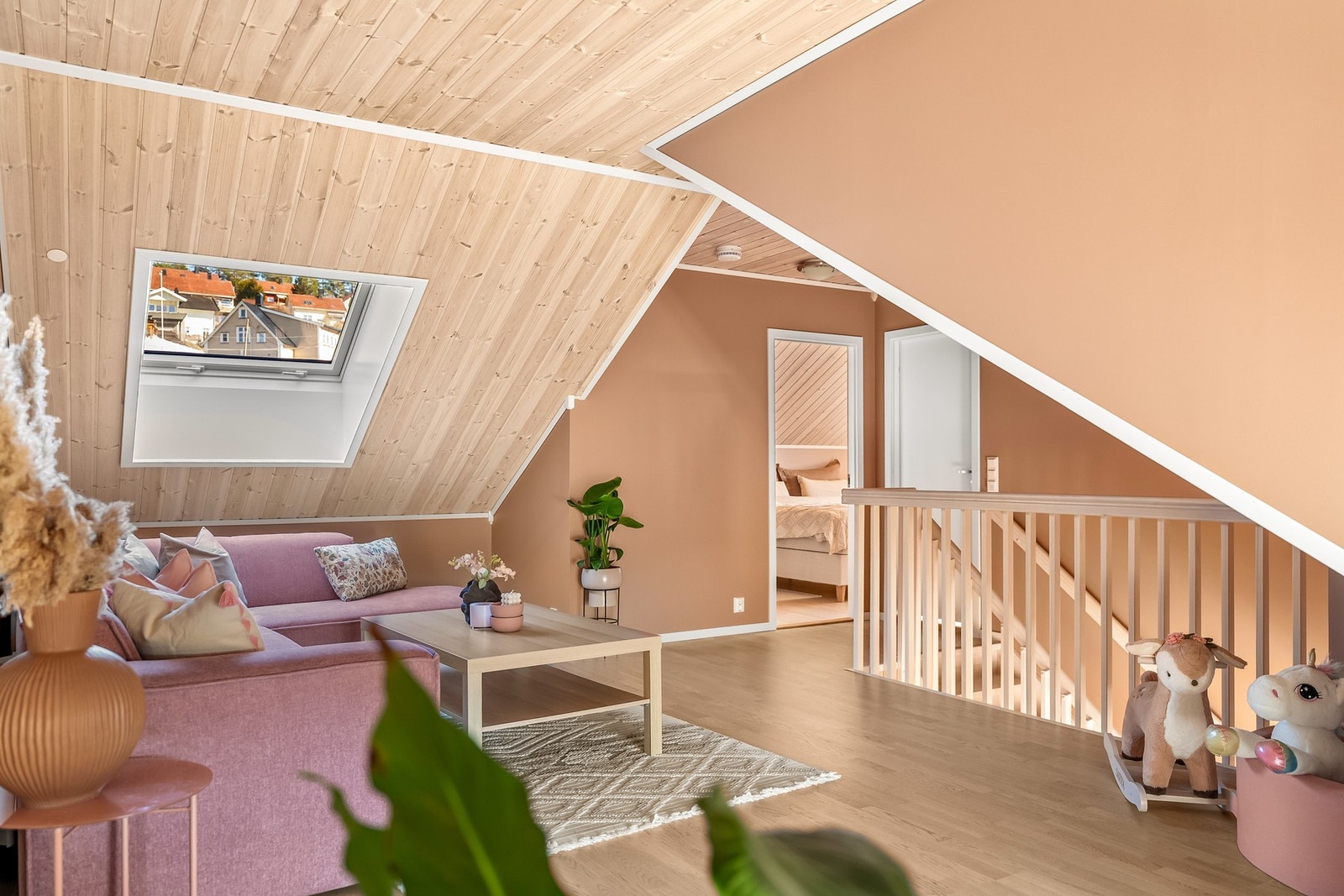 Rommet har malte veggflater og gulvoverflater med parkett. Den skrånende himlingen skaper en koselig atmosfære, og takvindu byr på fin, naturlig lyssetting. Galleribilde