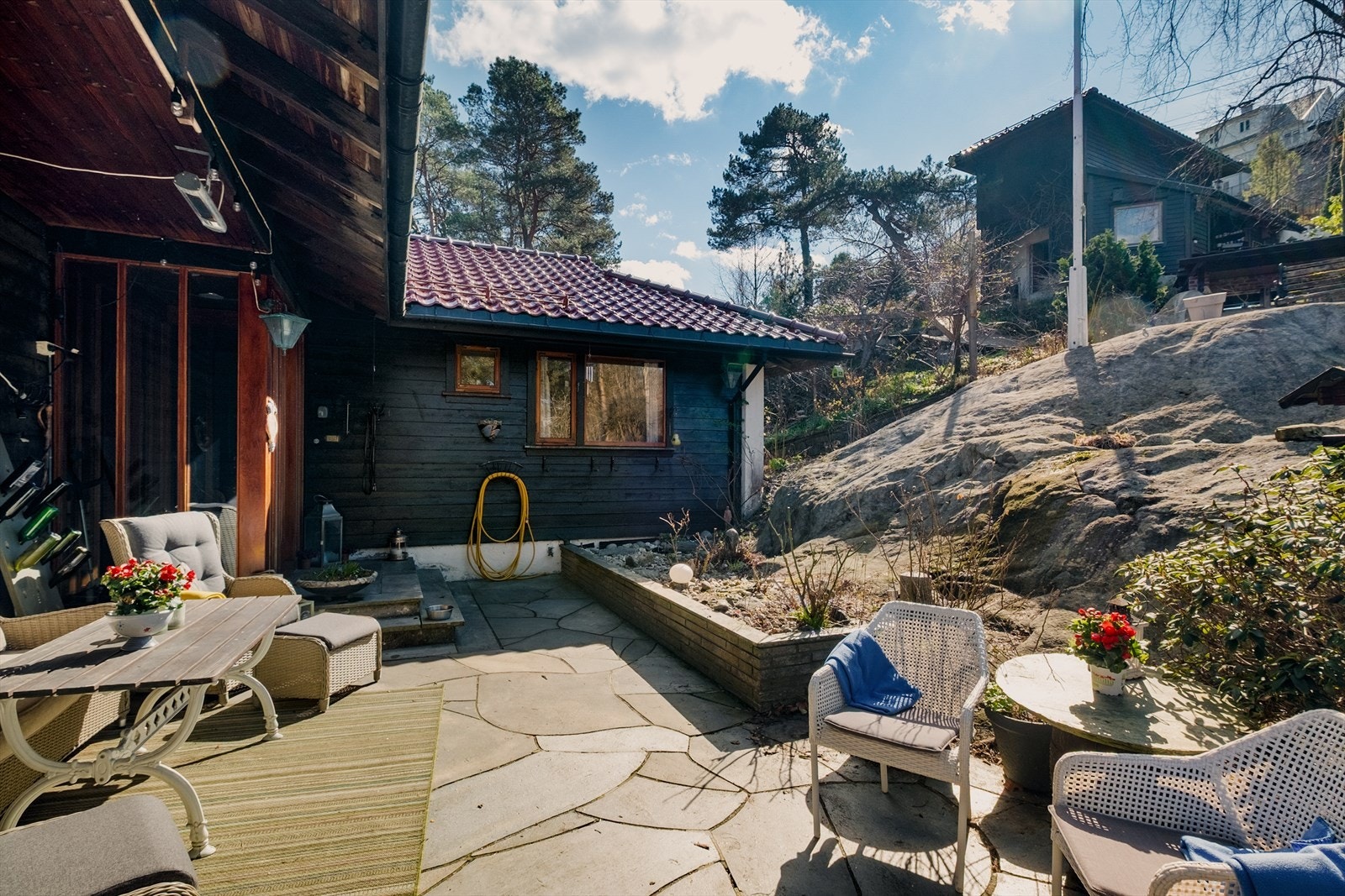 Uteplass med skiferheller, en lun sone med god plass til utemøbler. Galleribilde