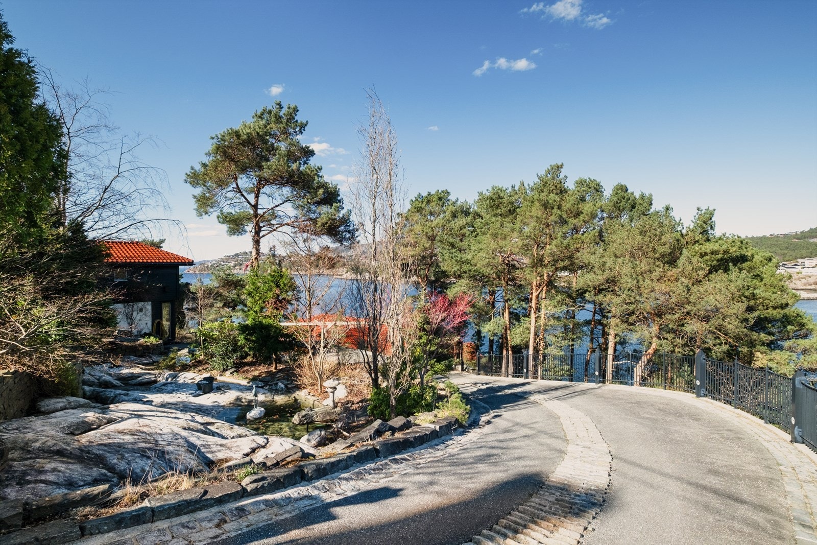 Privat vei fører ned til eiendommen, som ligger fredelig til i enden av en blindvei. Man eier og tomten på høyre side av veien. Galleribilde