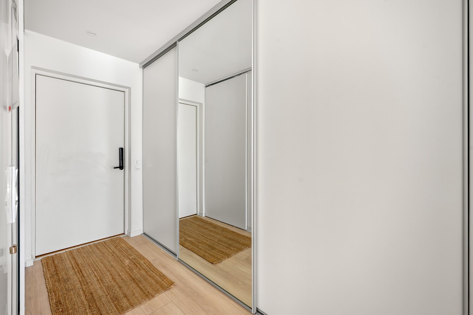 Inngangspartiet i første etasje er lyst og innbydende, med skyvedørsgarderobe med speilfronter for rikelig med oppbevaring. Galleribilde