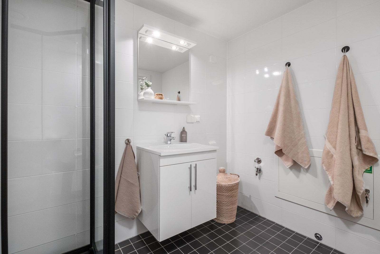 Pent bad med fliser på gulv og vegg. Opplegg for vaskemaskin, vegghengt toalett og dusjkabinett. Galleribilde