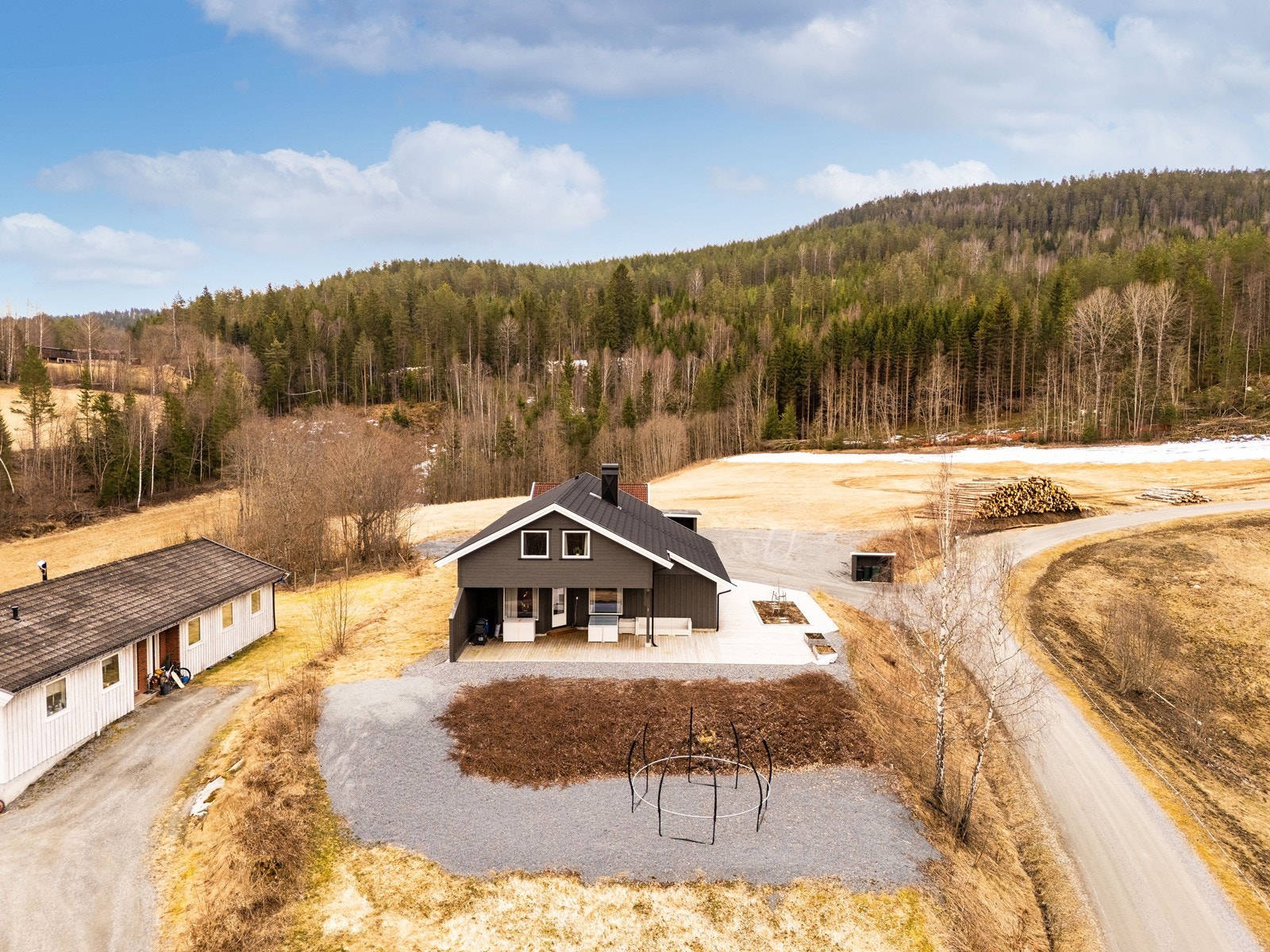 Eiendommen ligger i et skrånende terreng med en flat og opparbeidet tomt rundt boligen. Galleribilde