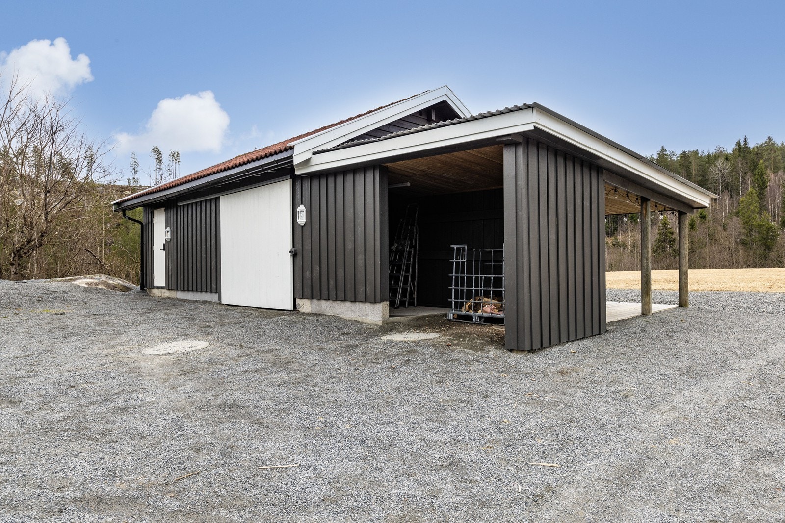 Garasje på 42 m² bygget i 2011, med et tilhørende takoverbygg for lagring fra 2020. Galleribilde
