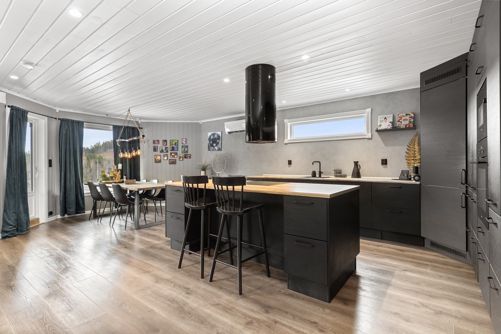 Kjøkkenet fra 2019 har en praktisk kjøkkenøy med platetopp og sitteplasser. Innredningen har glatte fronter og laminat benkeplate. Galleribilde