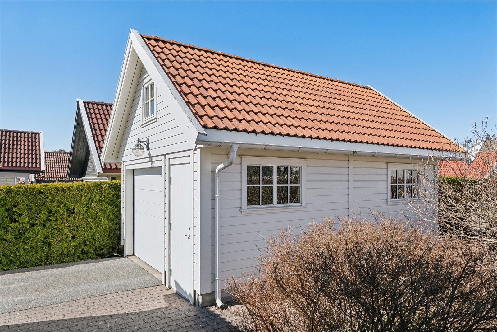 Eiendommen inkluderer en romslig garasje fra 2007 med automatisk portåpner fra 2021 og et praktisk lagringsloft. Galleribilde