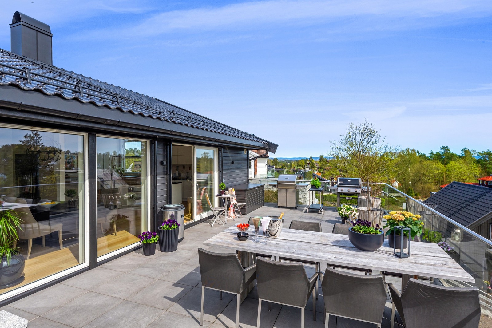 Flislagt terrasse på 64 m2 med høyttalere i takskjegg og flere strømuttak Galleribilde