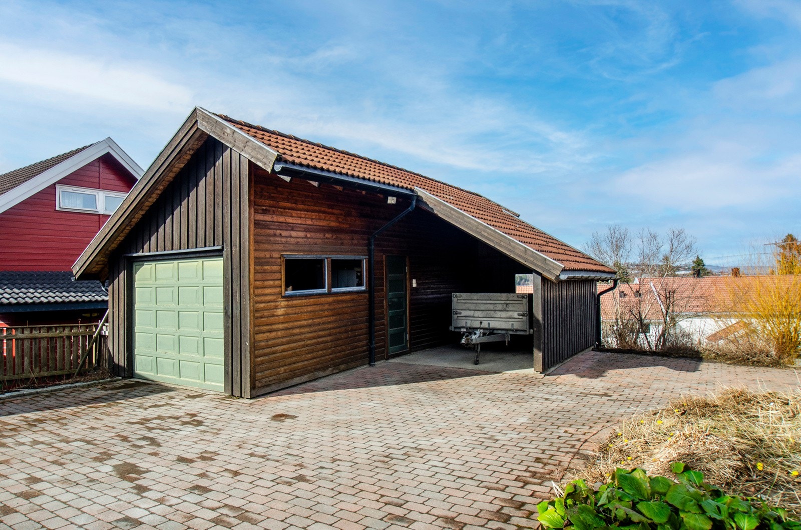Ekstra lang garasje med mulighet for å parkere 2 biler. I tillegg carport. Galleribilde