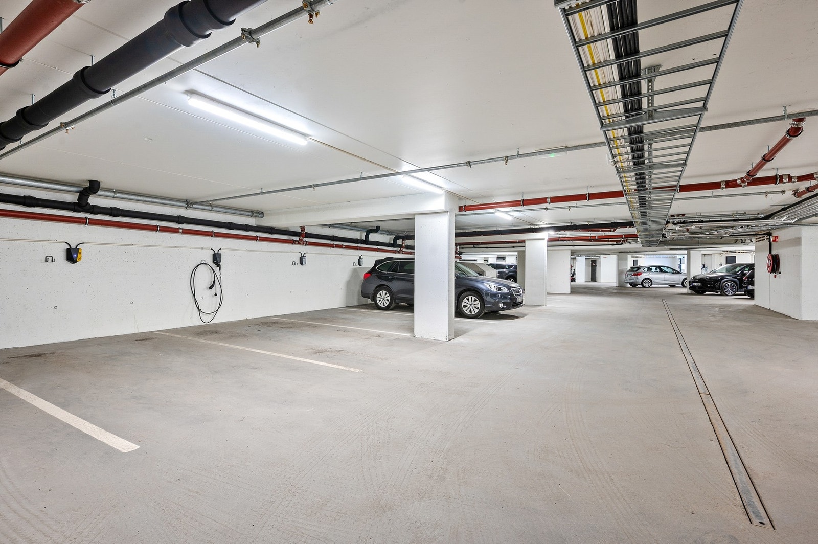 Medfølgende parkeringsplass i lukket garasje. Det er klargjort for å montere elbil-lader (plassen til venstre i bildet) Galleribilde