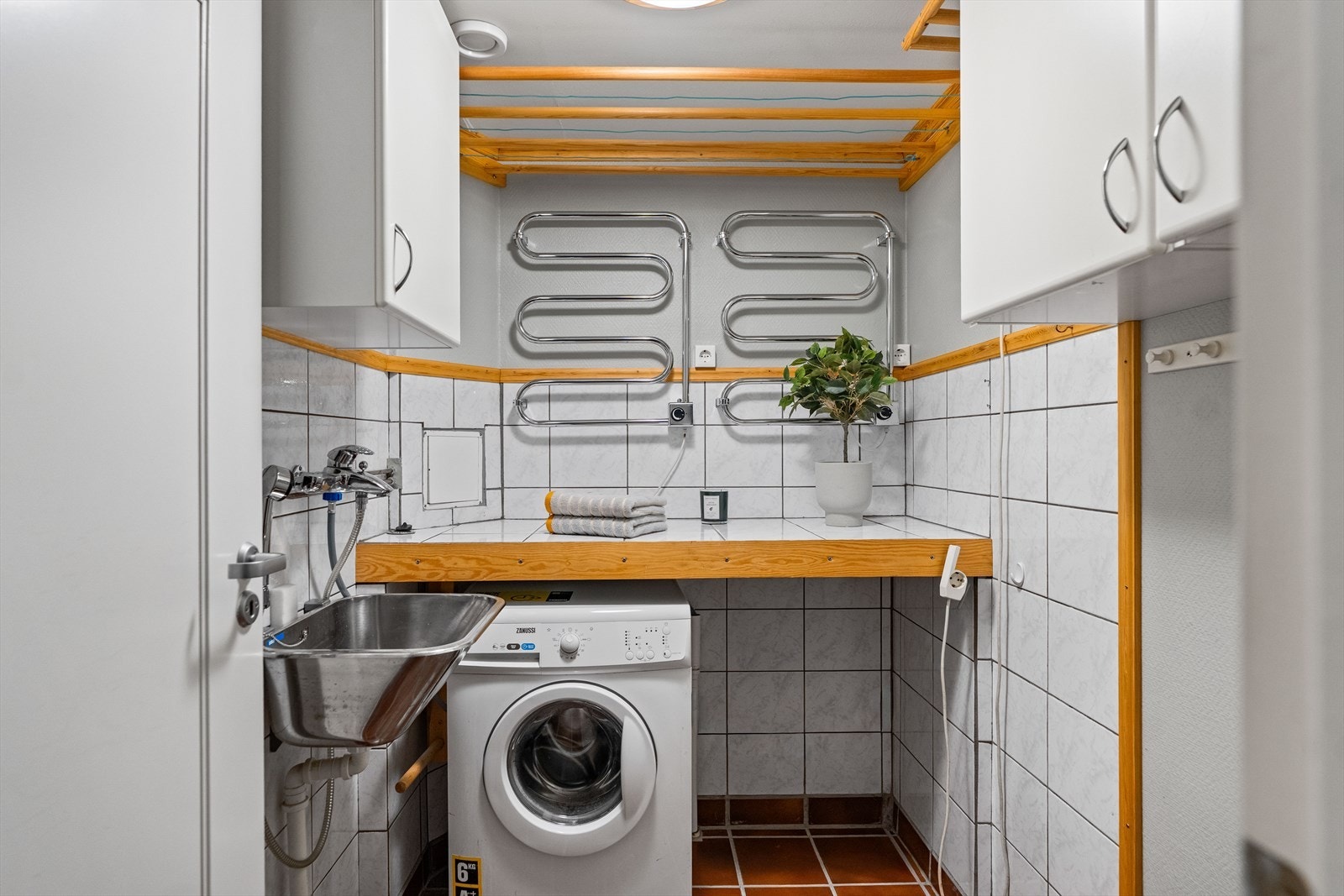 Fra gangen er det også inngang til et vaskerom. Rommet har skapinnredning, utslagskum og opplegg for vaskemaskin. Galleribilde