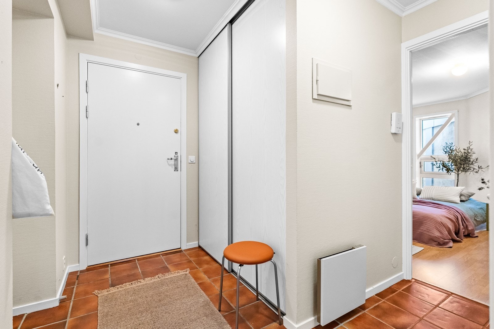 I entréen er det plass til å henge fra seg yttertøy i skyvedørsgarderobe. Det er fliser på gulvet. Galleribilde